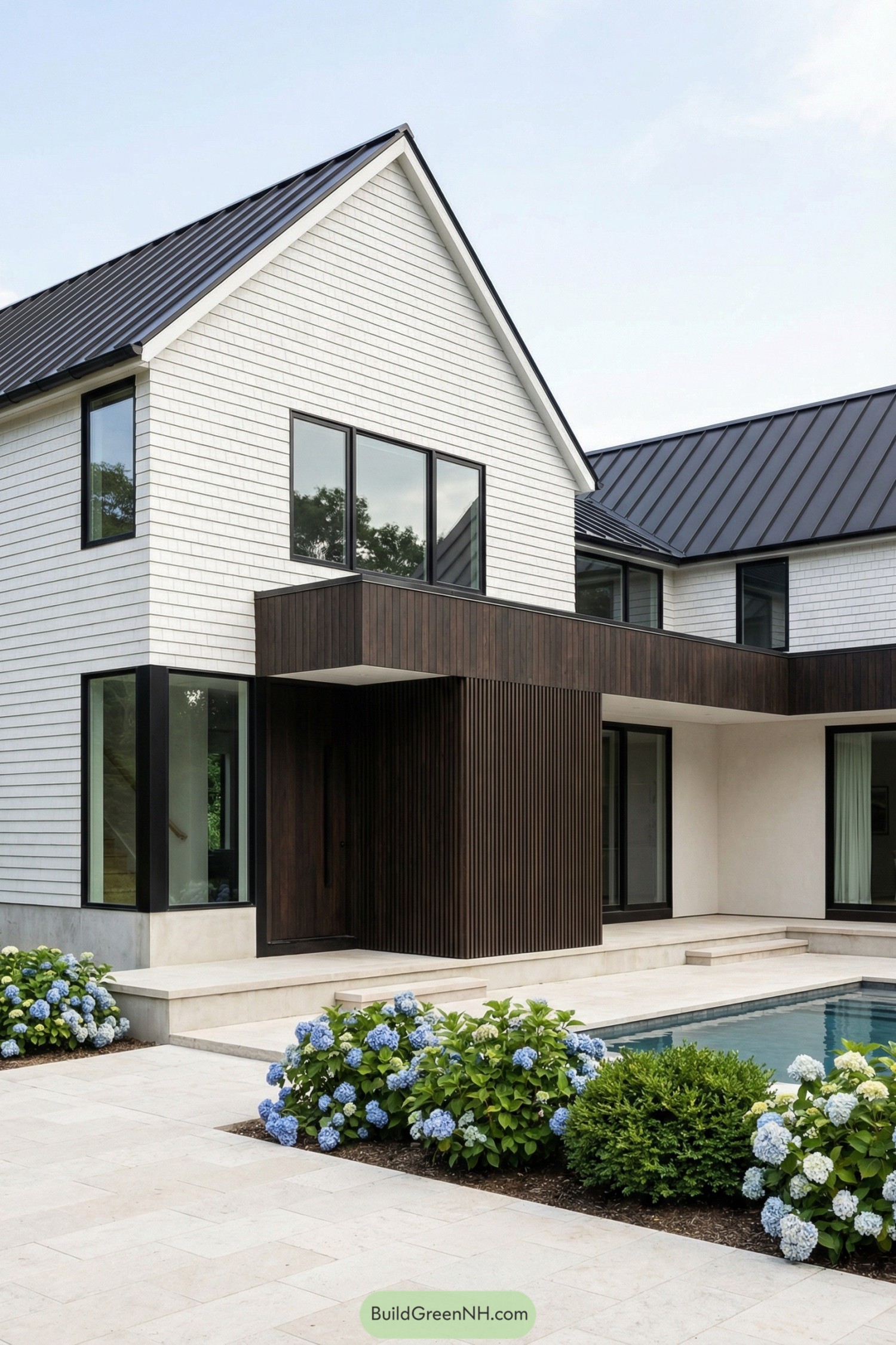Modern white gabled house with dark wood accents surrounding a courtyard pool
