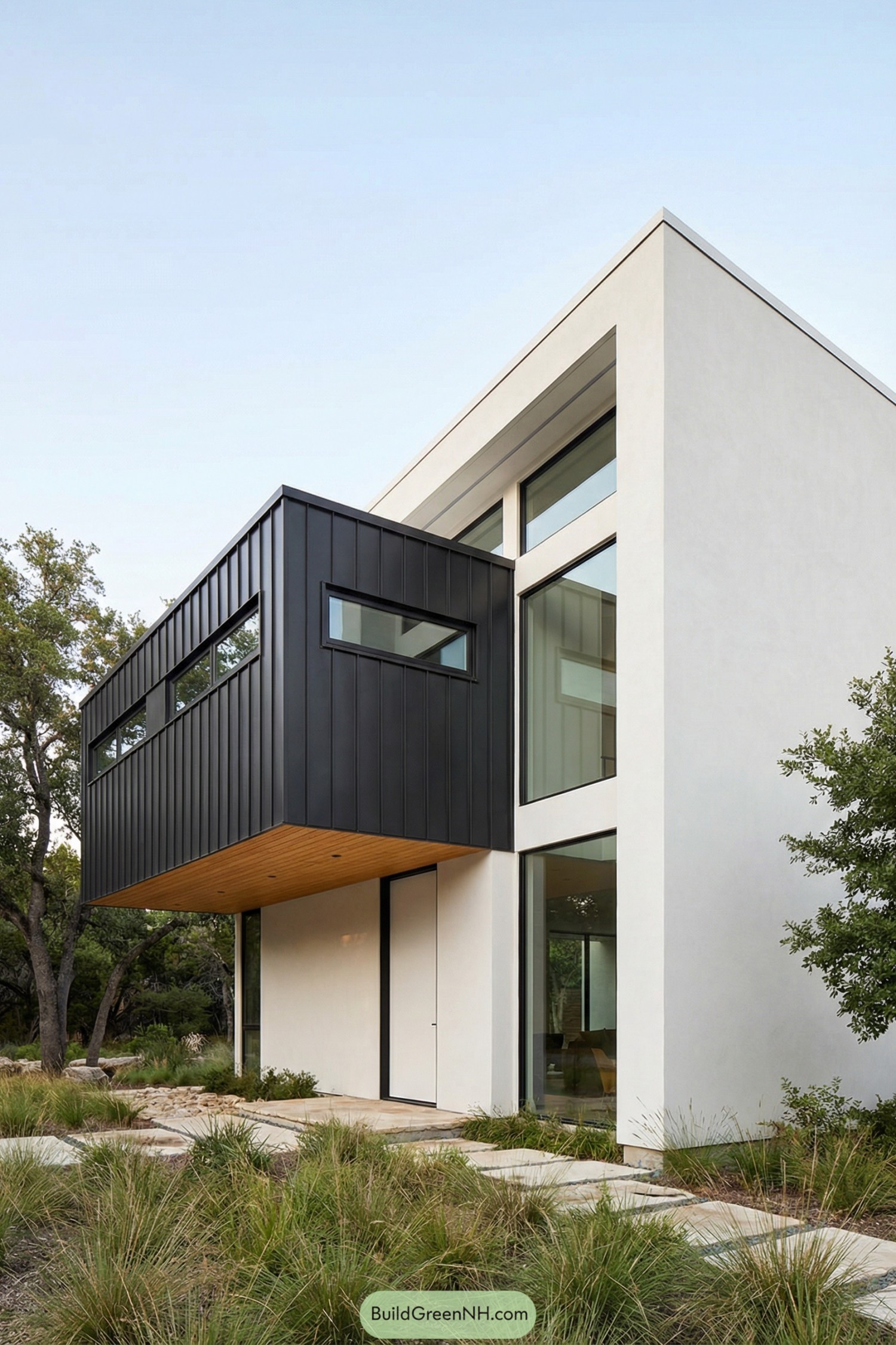 Modern white stucco house with black metal cantilevered volume over a native grass garden
