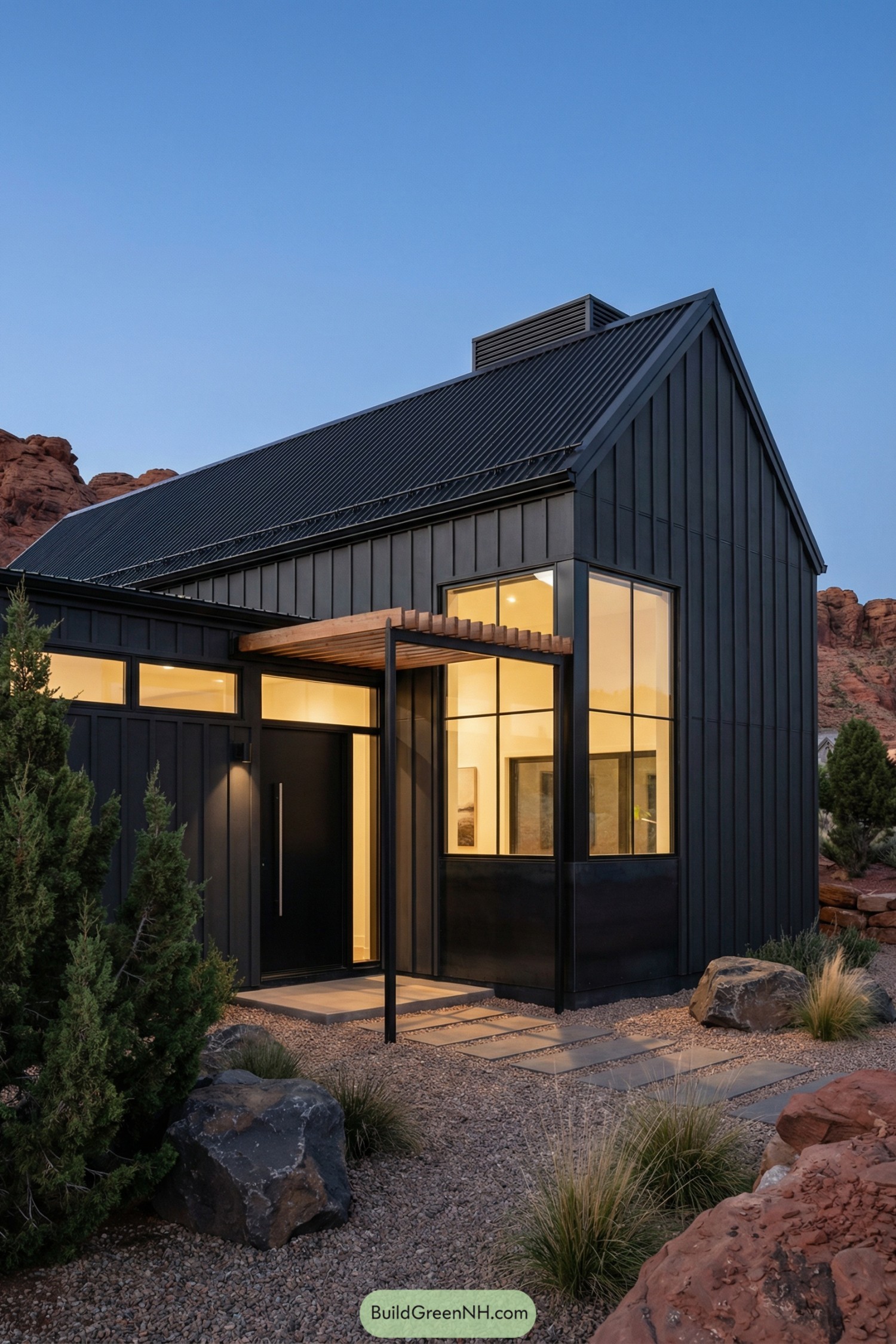 Sleek black barndominium with tall windows in a rocky desert setting