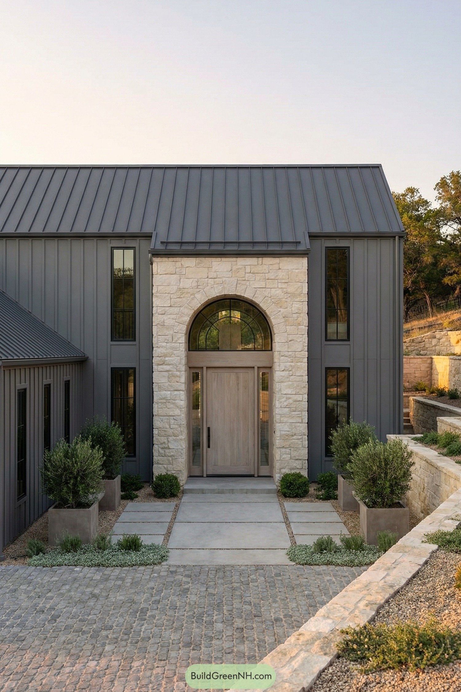 Modern grey barndominium with tall stone entry