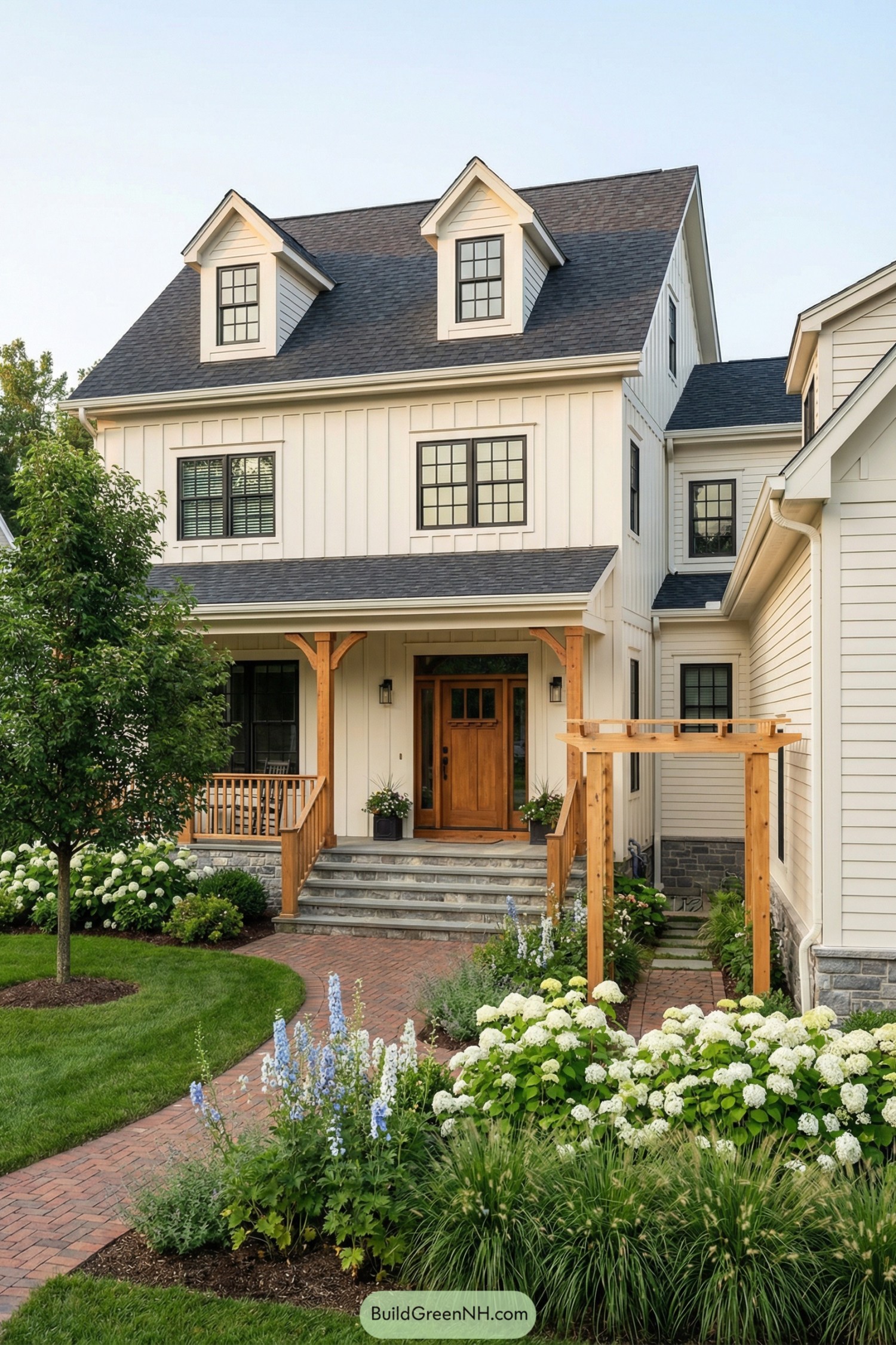 Warm white farmhouse with wood porch and lush garden entry