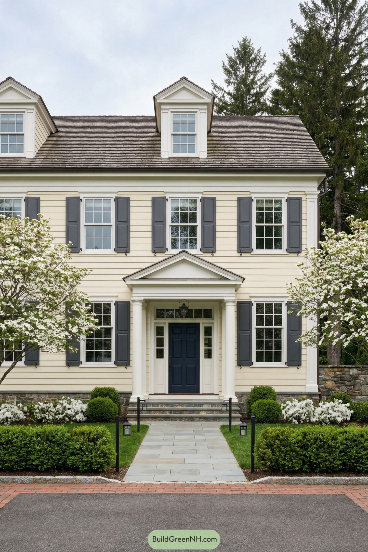 Classic cream clapboard house with blue shutters and a formal front garden path