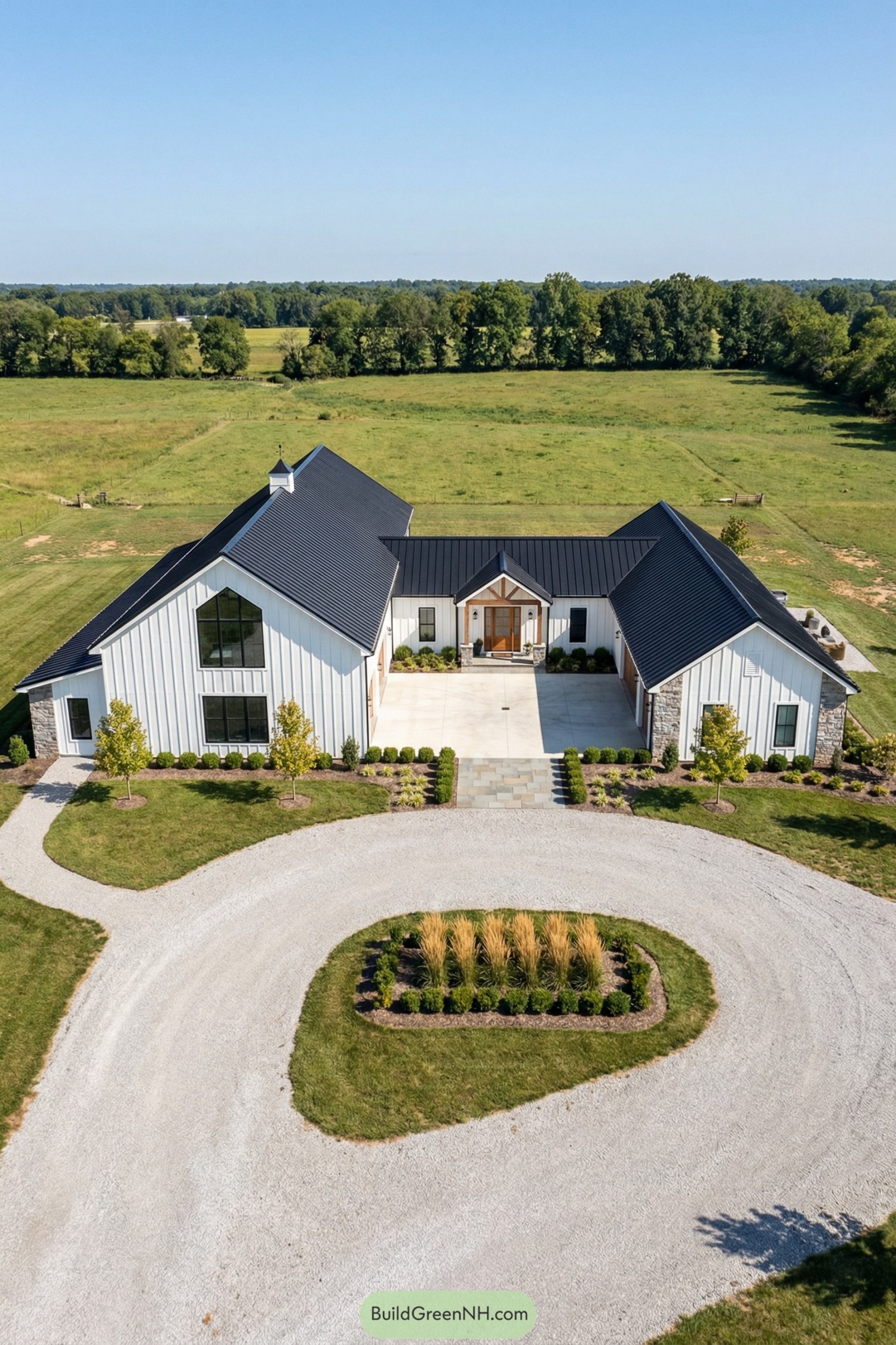 Aerial view of a white modern farmhouse barndominium with black roof and circular gravel driveway