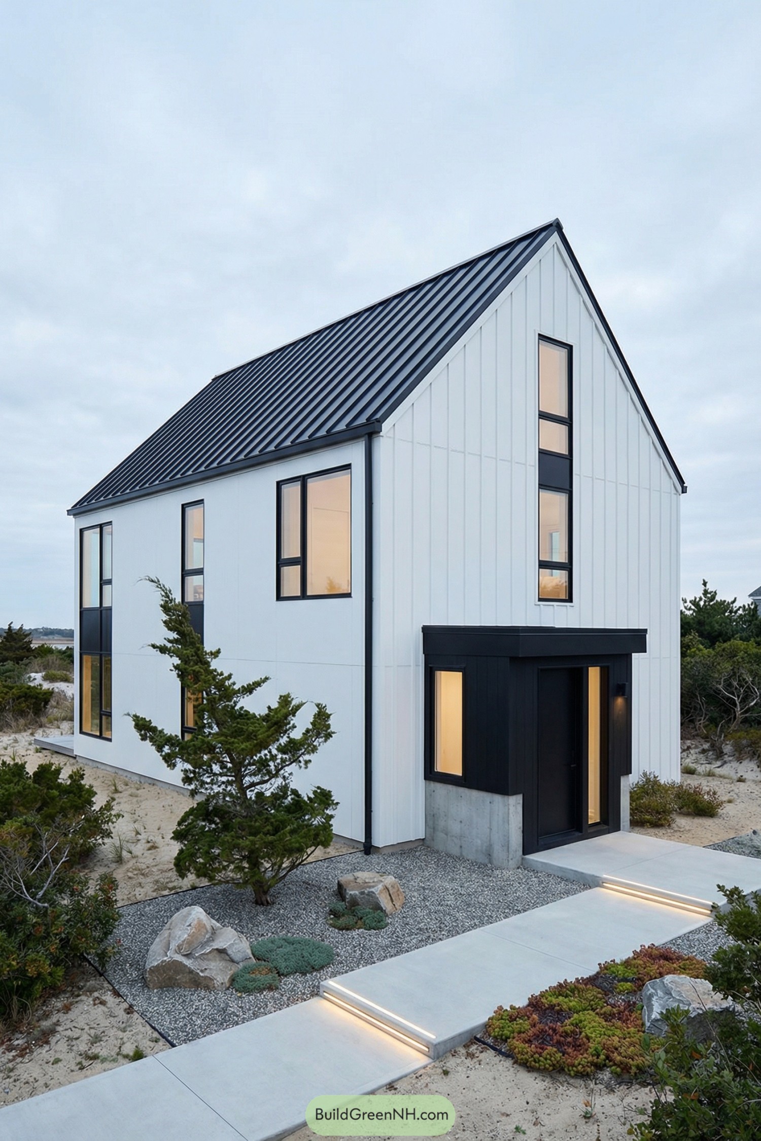 Slim black and white modern farmhouse set among sandy coastal dunes