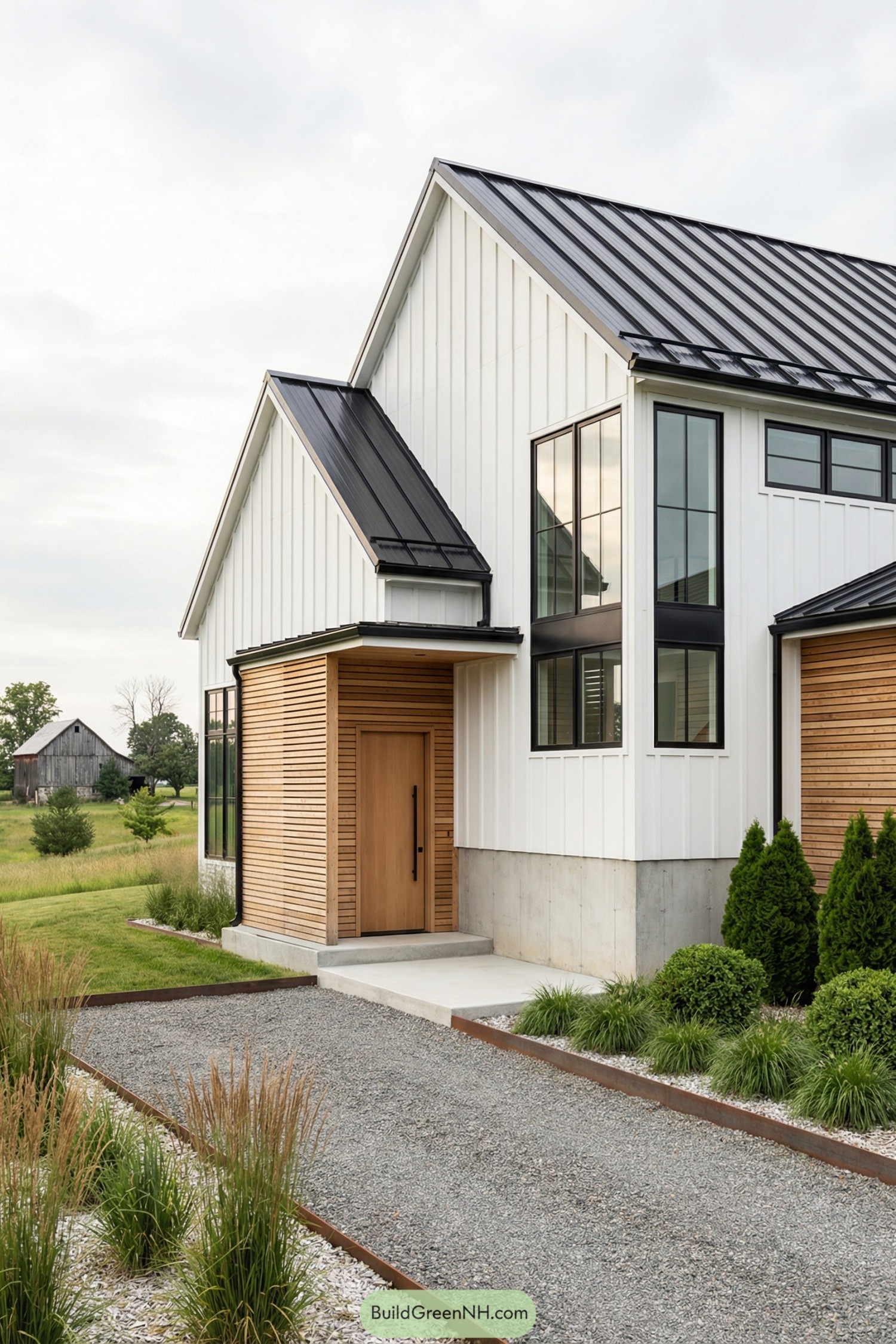 Modern white barndominium with black metal roof and warm wood entry accents
