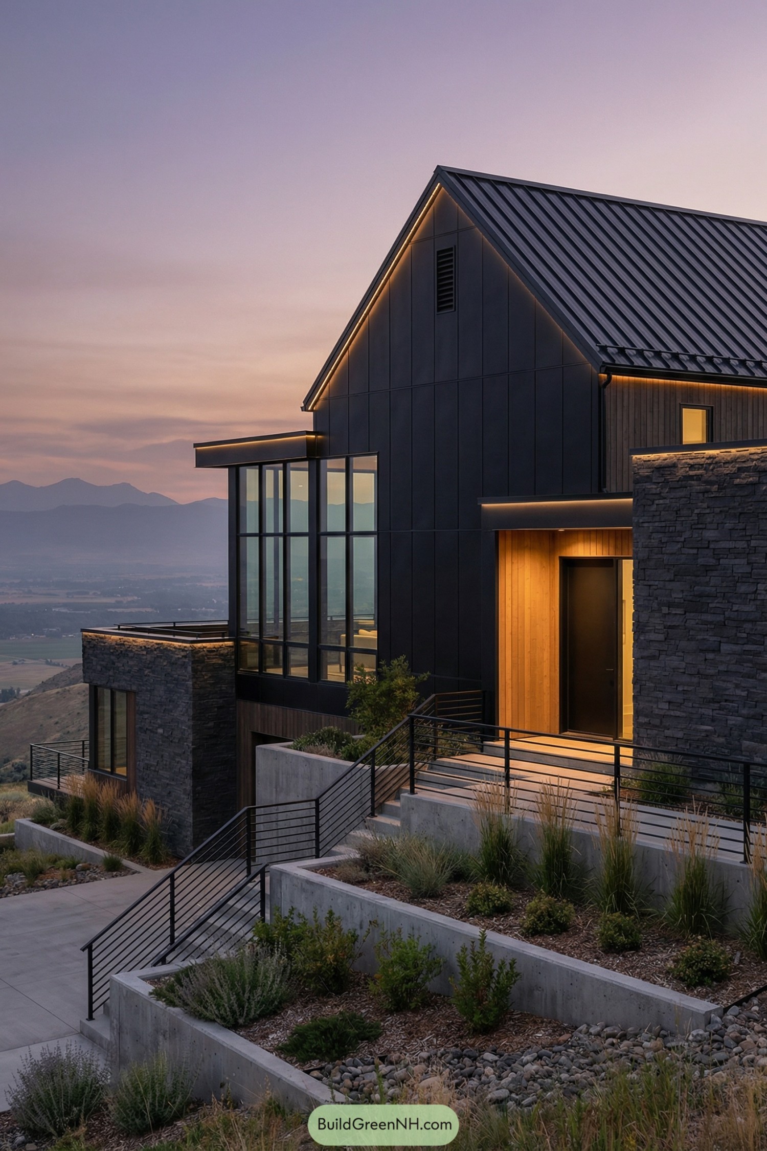 Dark modern barndominium on a terraced hillside at dusk