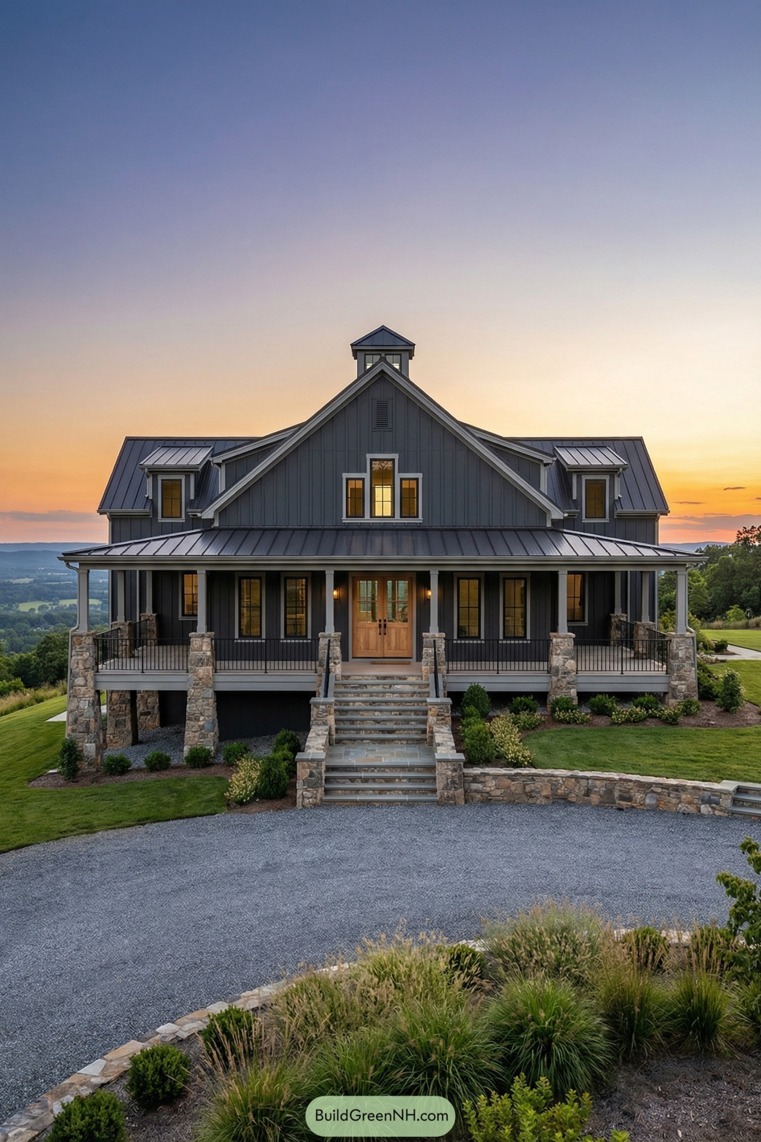 Dark grey barndominium with wraparound porch and stone pillars at sunset