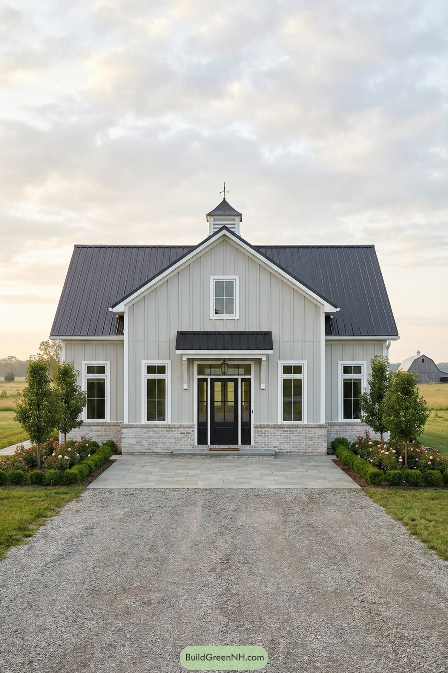 Grey barndominium with black metal roof and symmetrical farmhouse façade