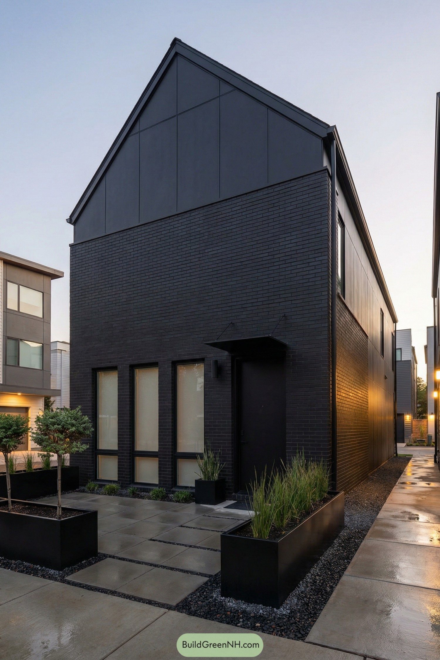 Tall black gabled barndominium with minimalist landscaping and sleek modern finishes