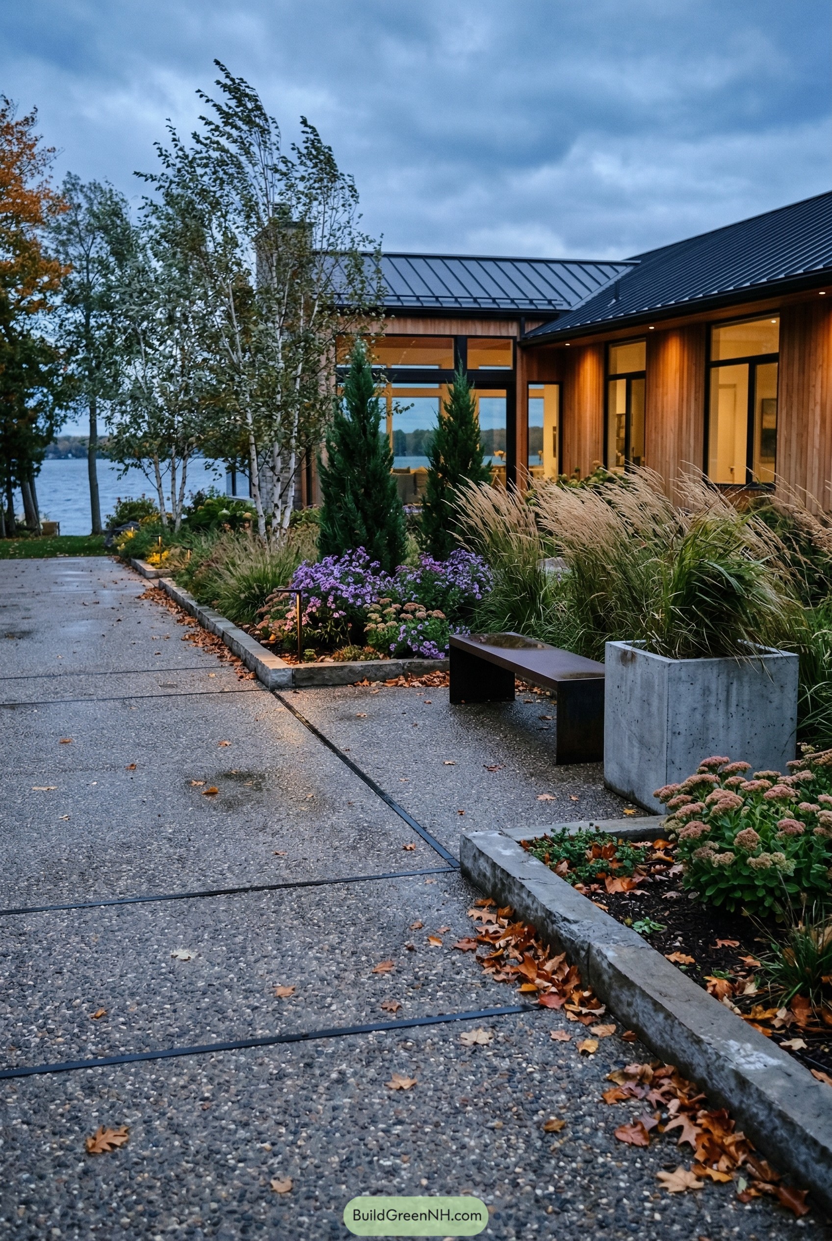 Exposed aggregate driveway with grasses birches and concrete edging