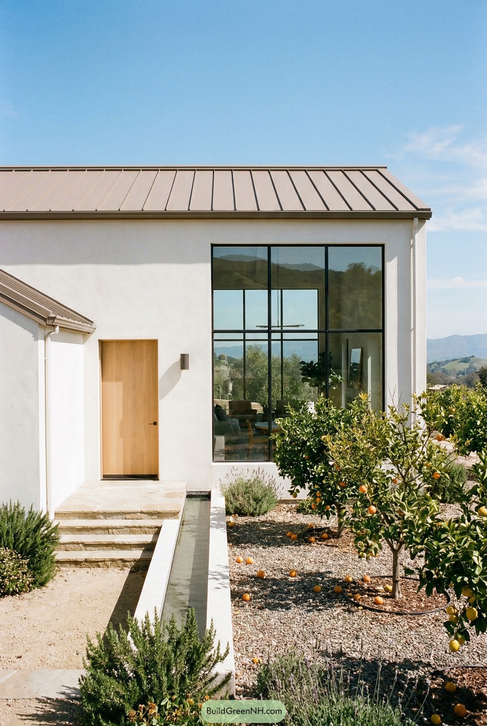 White stucco farmhouse with cathedral window and citrus garden