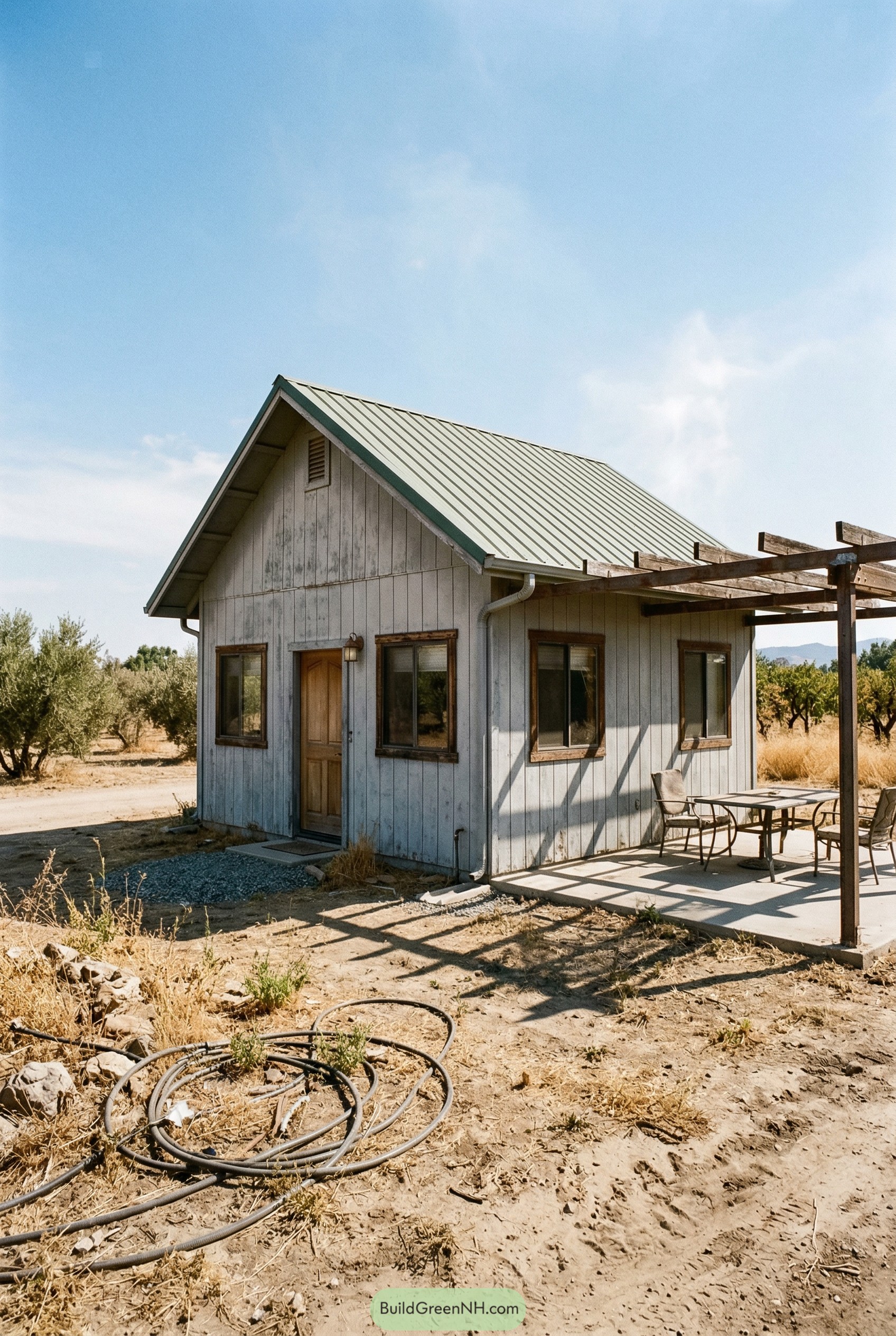 Small gray barndominium with pergola patio