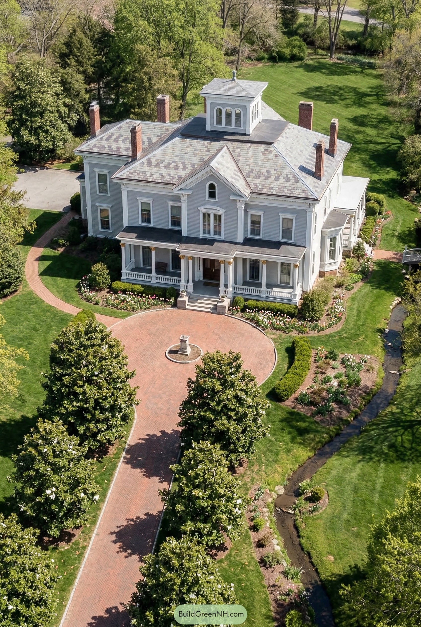 Gray Victorian mansion with cupola and circular brick drive