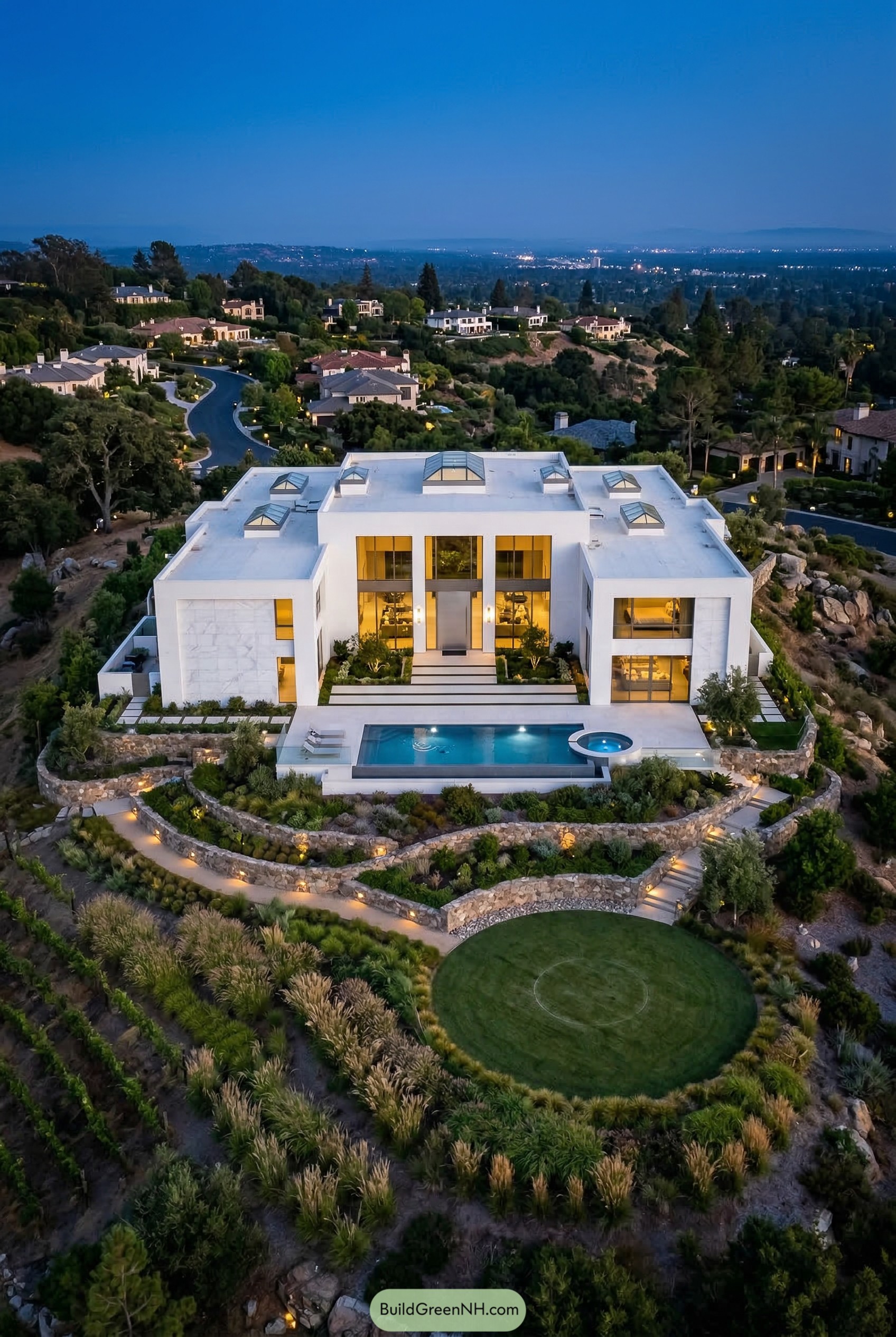 Modern white hillside mansion with pool at dusk