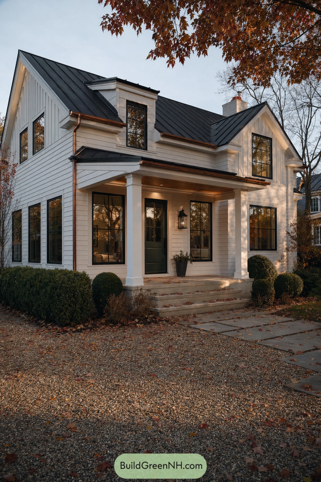 White colonial style house with black metal roof and porch