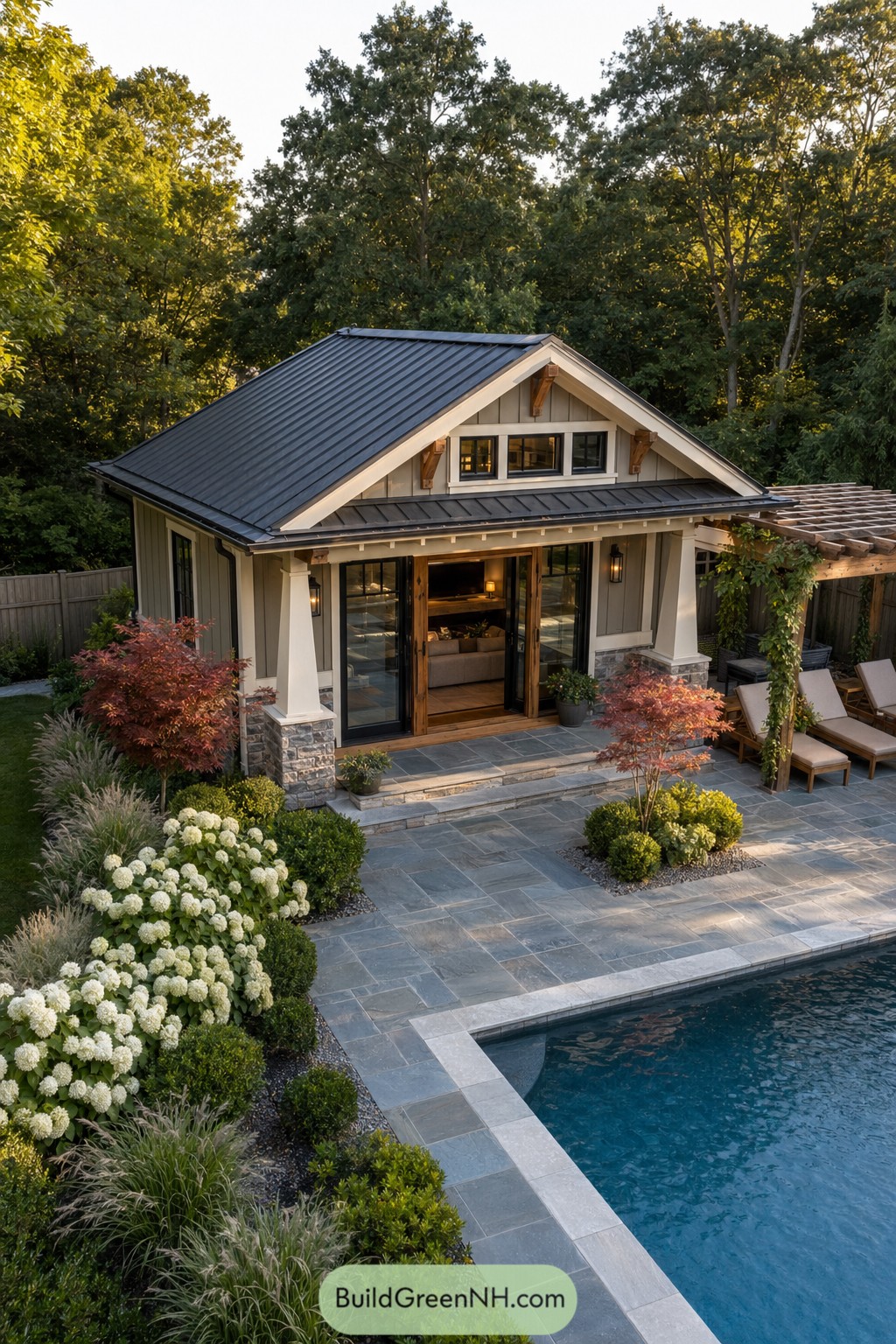 Modern craftsman pool house beside stone patio and pergola