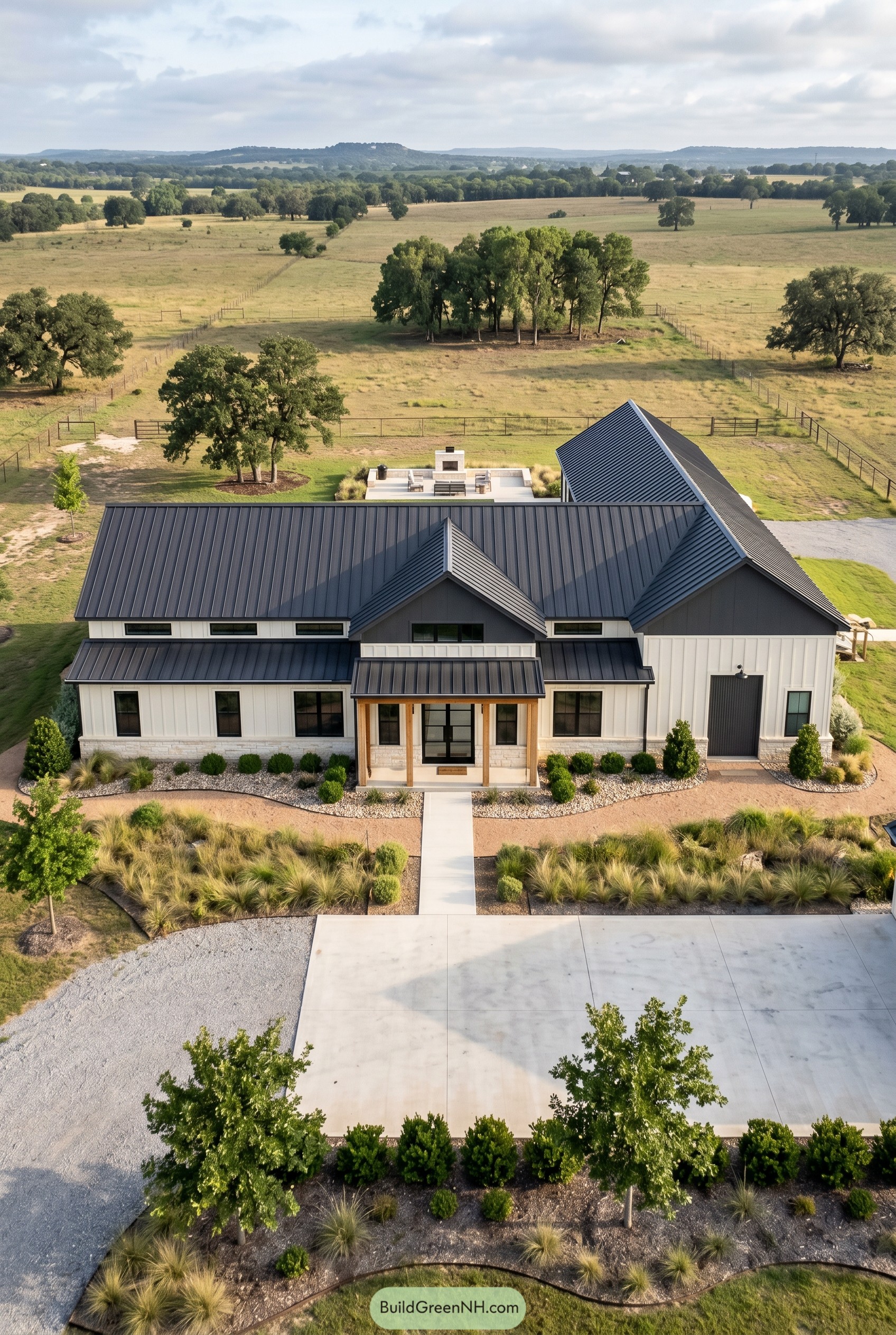 White modern barndominium with black gabled roof