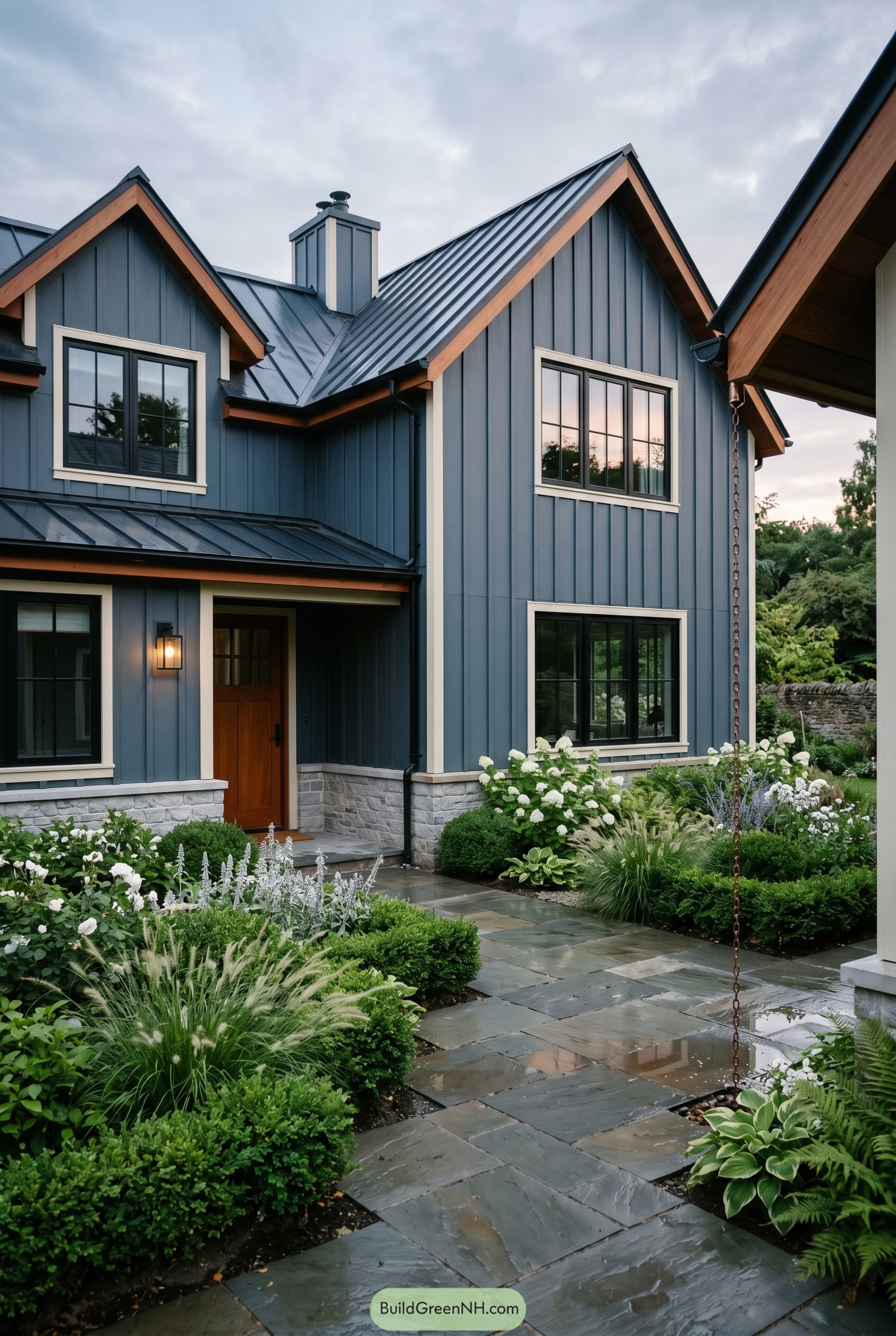 Deep blue cottage with black metal roof and lush garden path