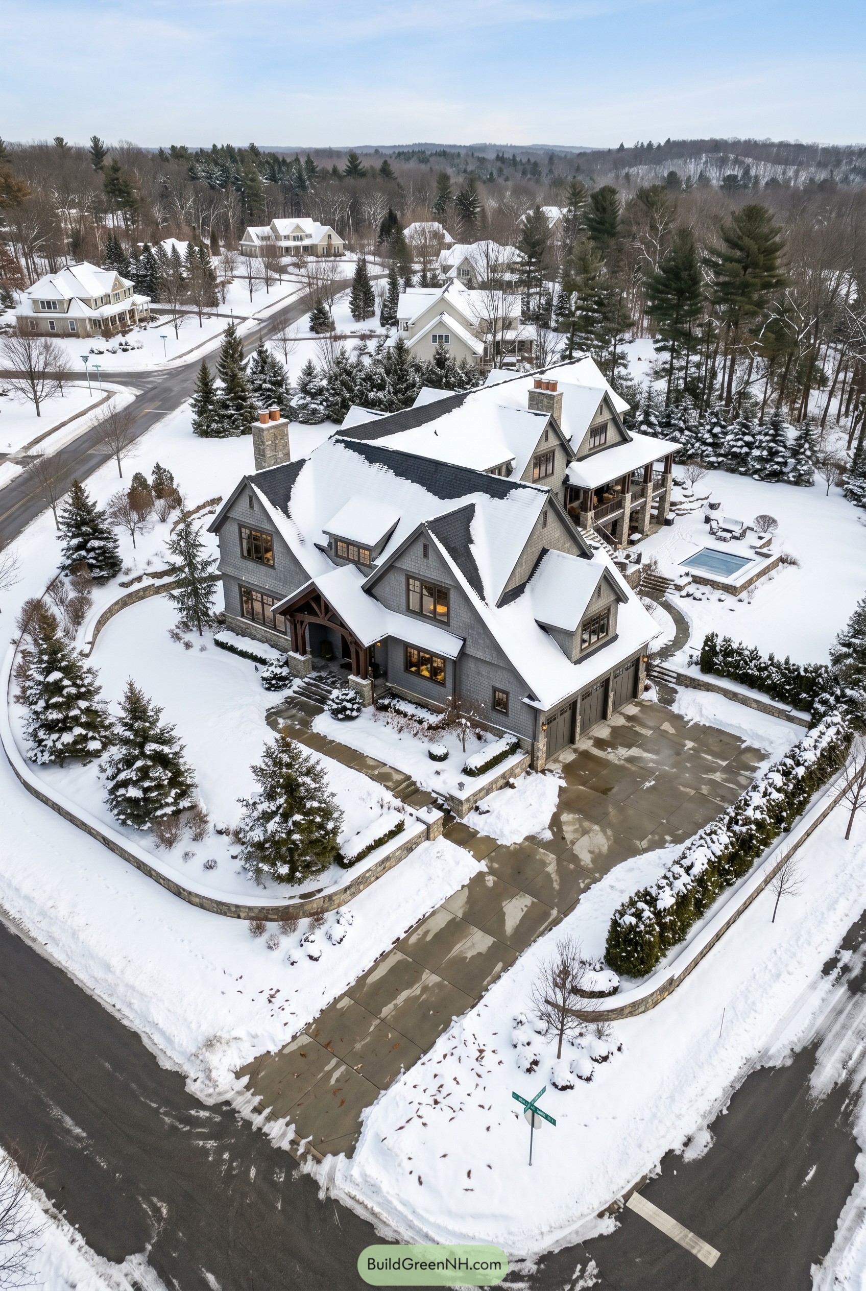 Snow covered gray shingle mansion with steep gables