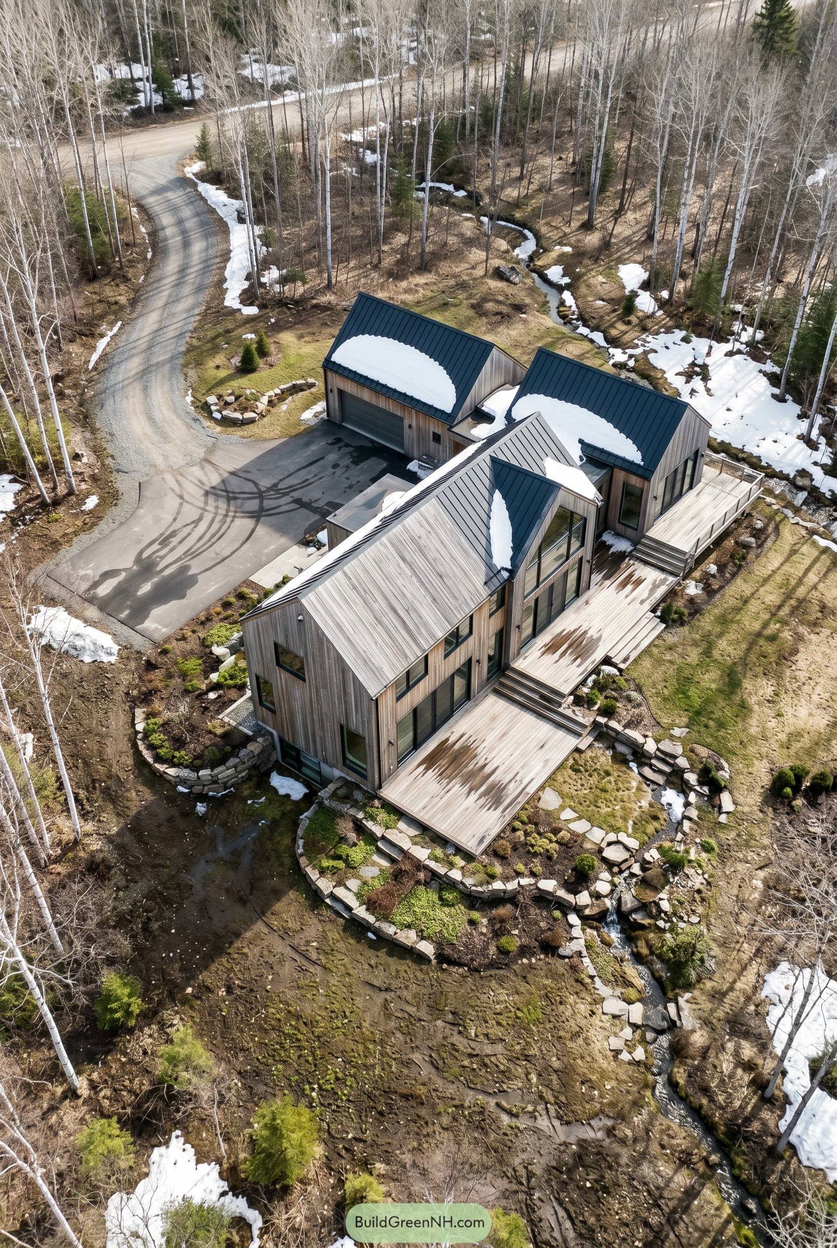 Aerial view of a cedar clad Nordic home by a creek