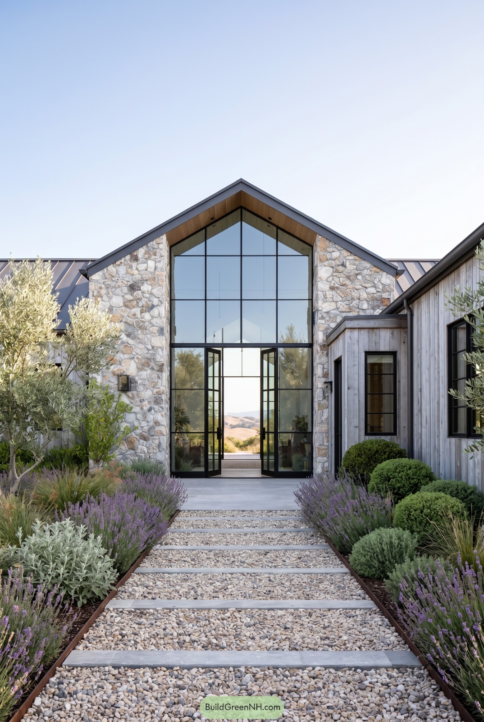 Modern farmhouse entry with stone gable and tall black framed glass