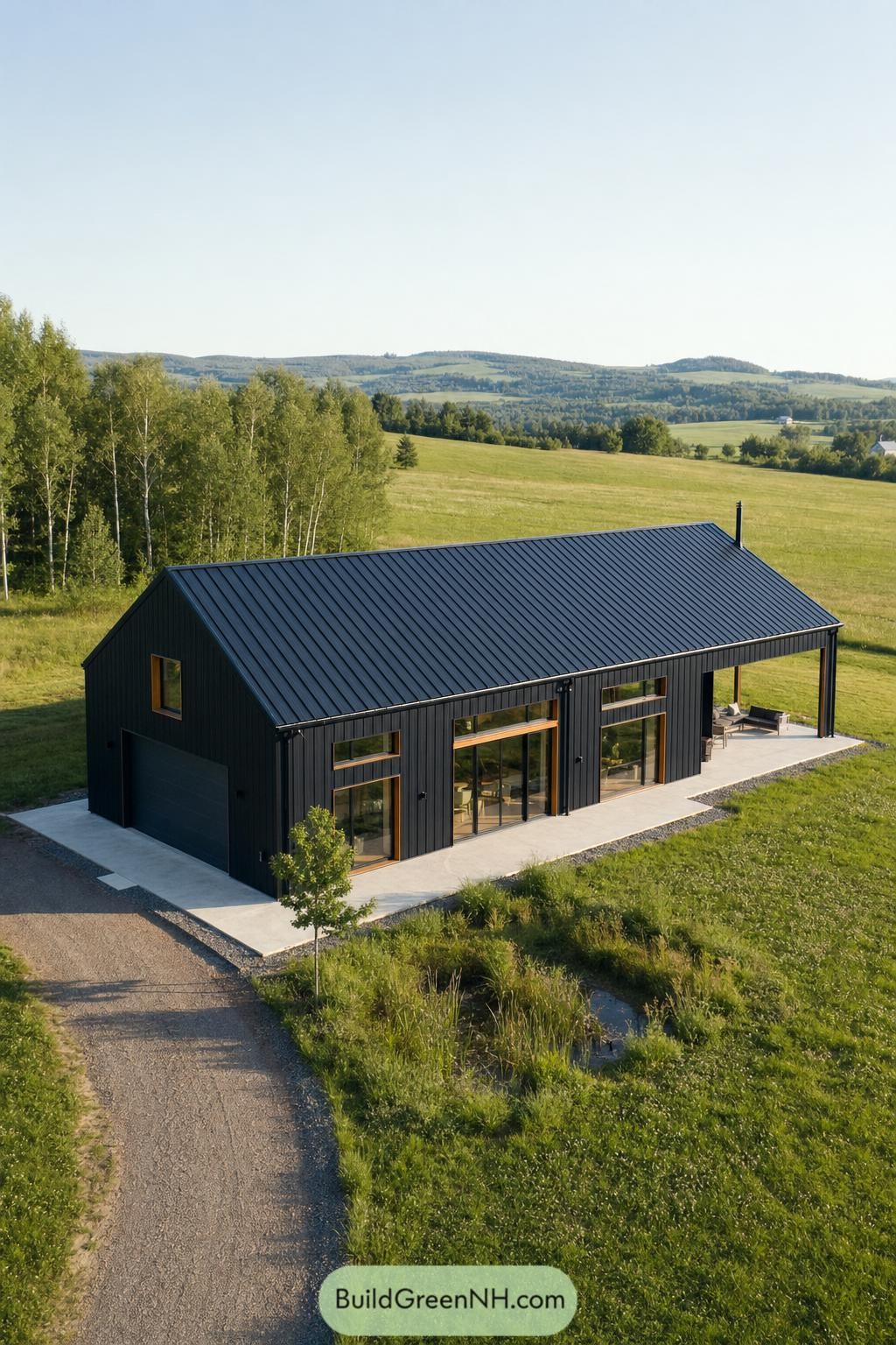 Black gabled barndominium with wood-framed glass doors in green hills