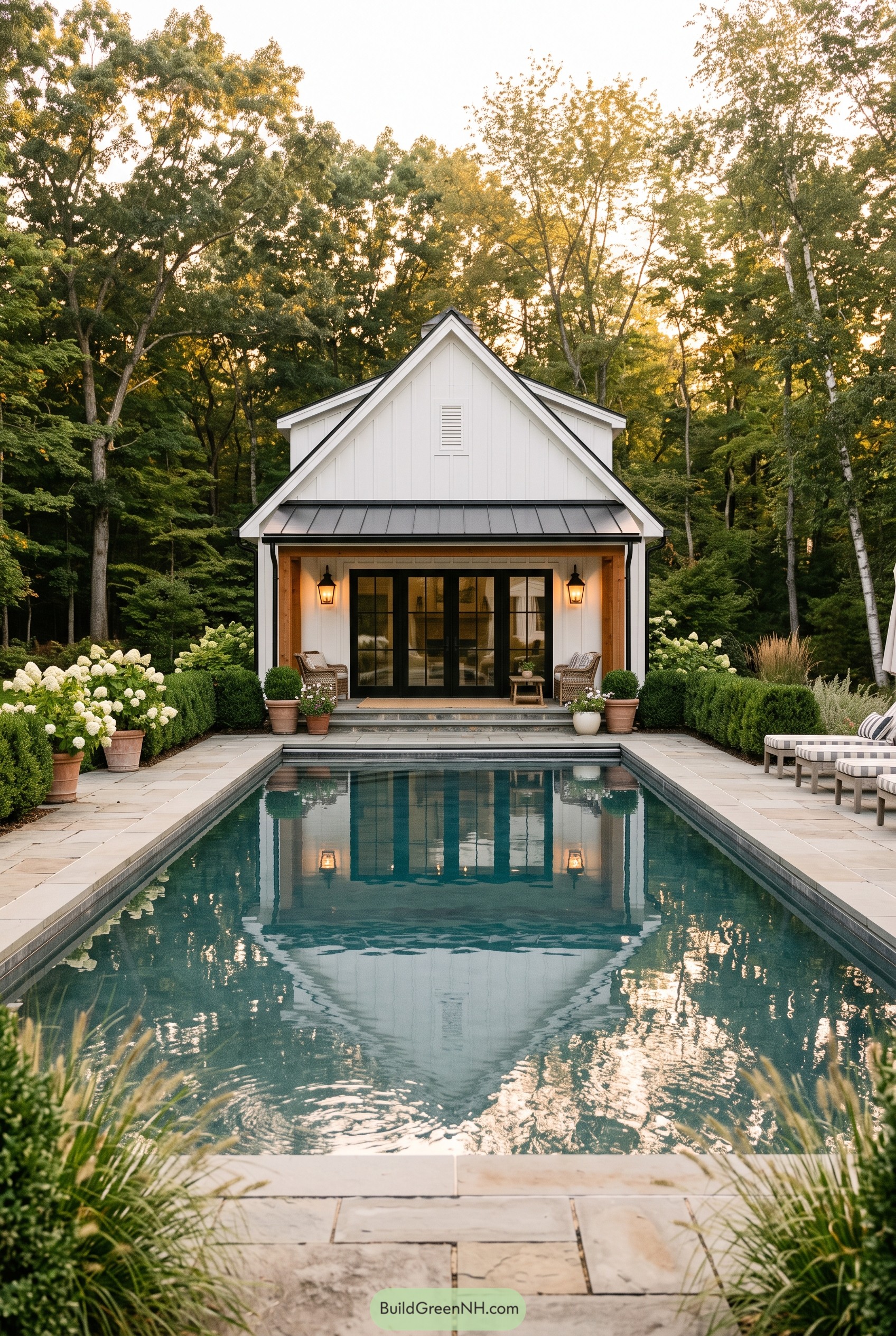 White farmhouse pool house beside a pool