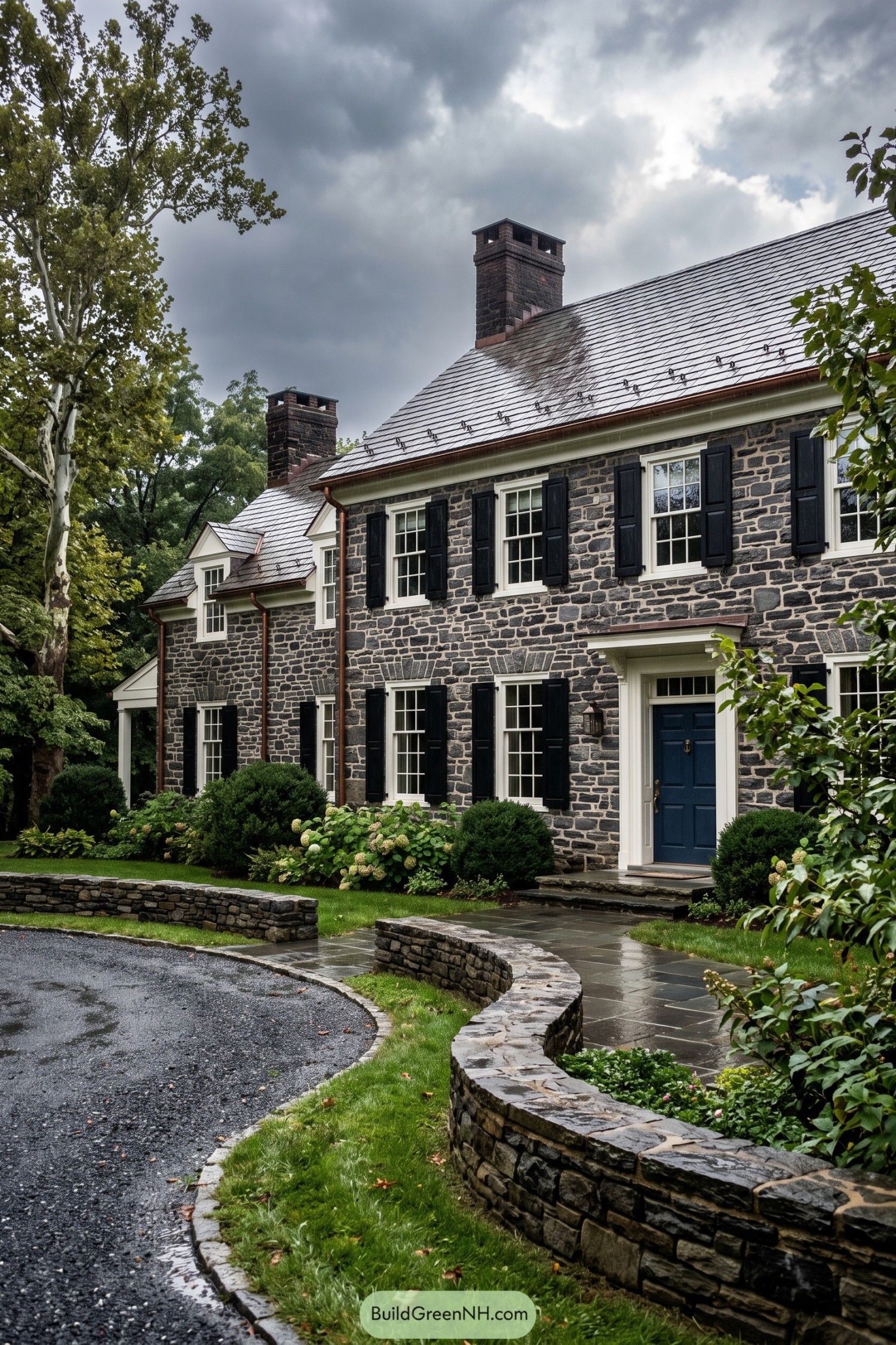 Dark fieldstone house with black shutters and slate roof