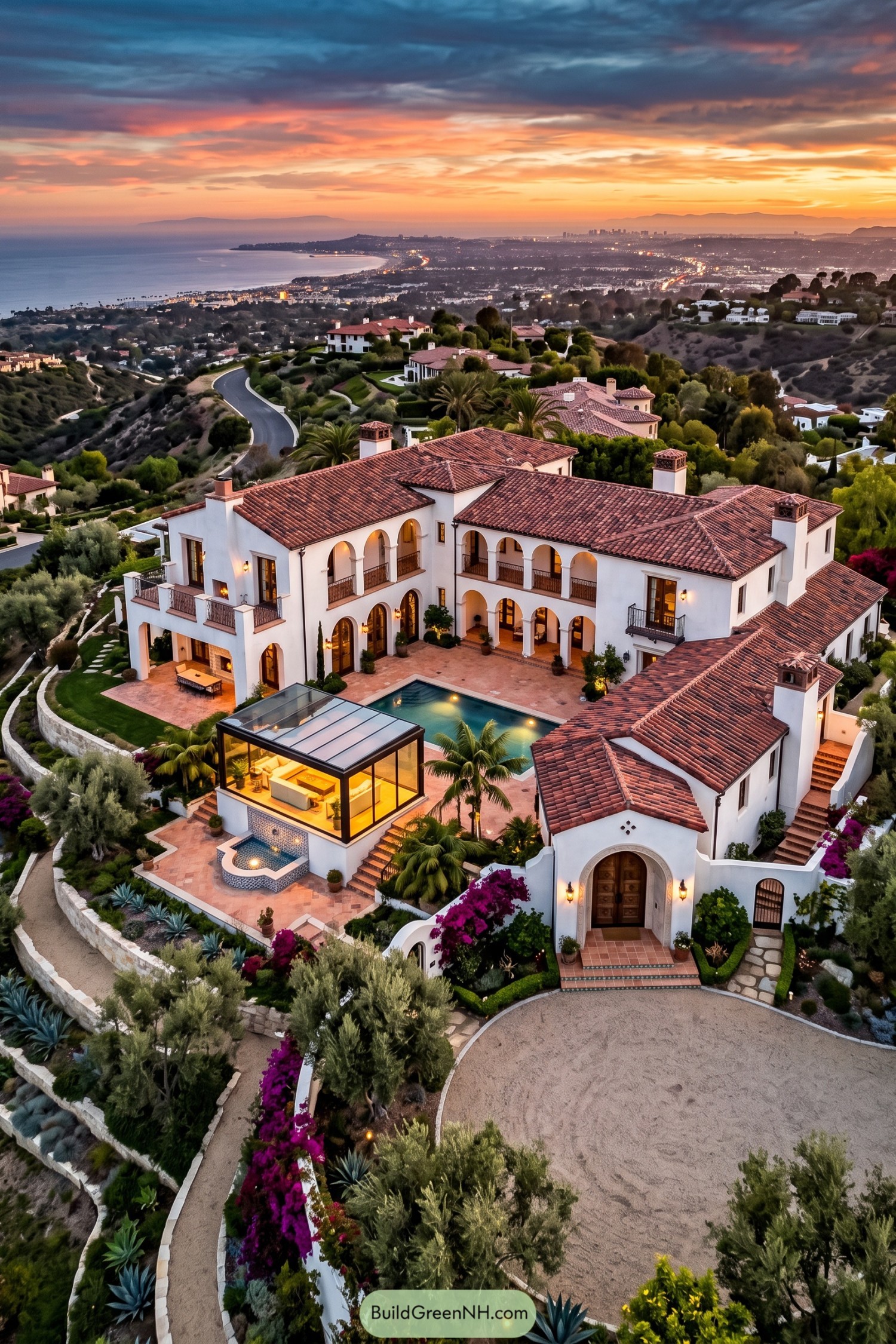 White stucco villa with tiled roofs overlooking the coast at sunset