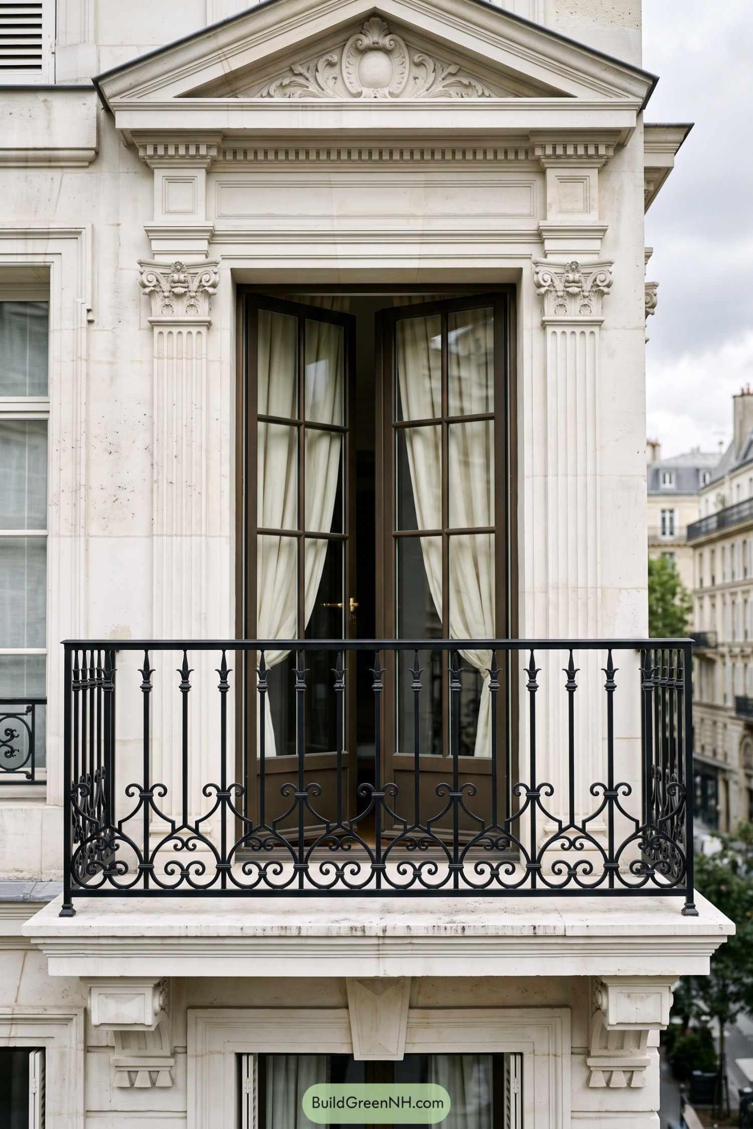 Black wrought iron balcony railing with scrollwork and spear finials