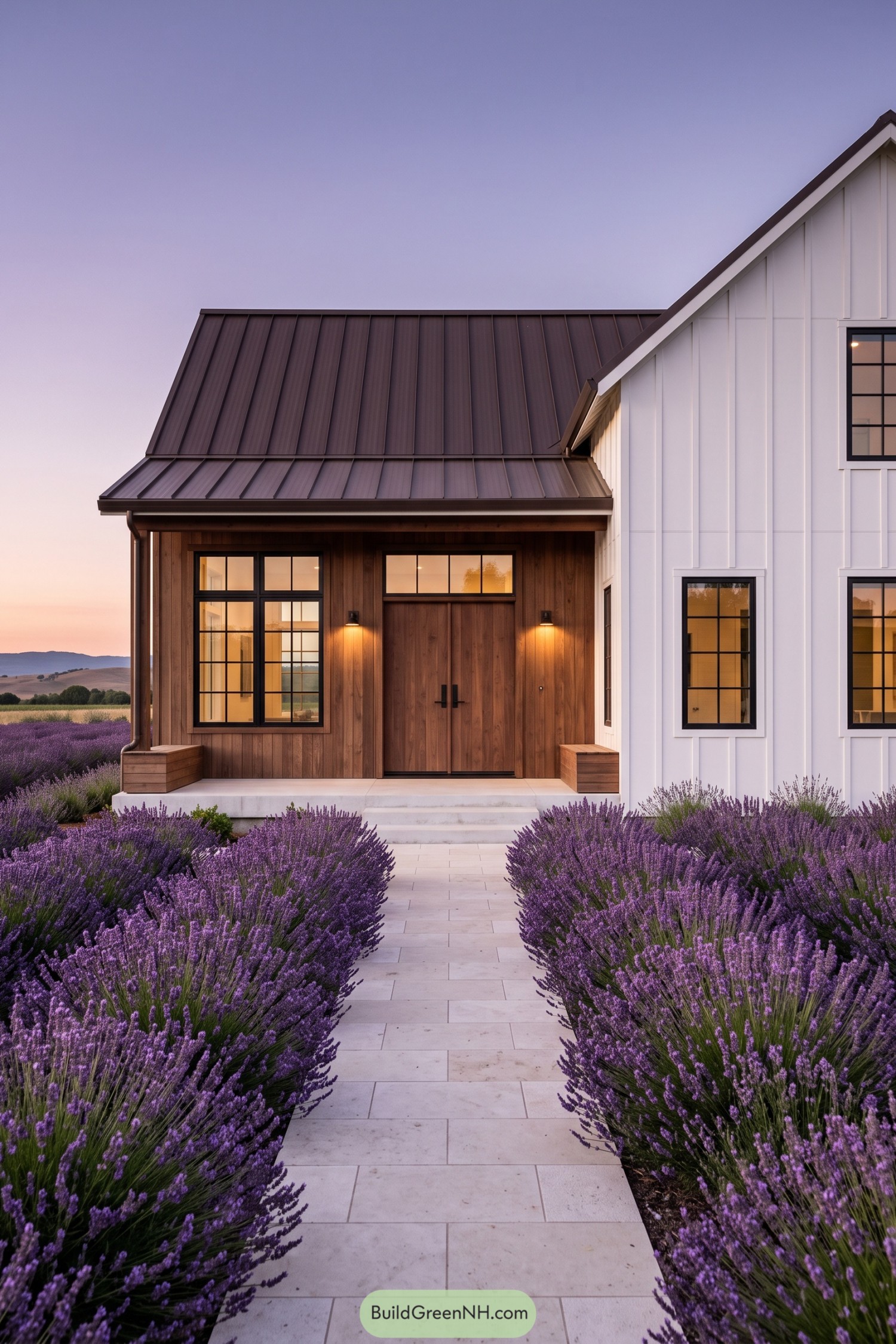 White and wood barn home framed by lavender beds at dusk