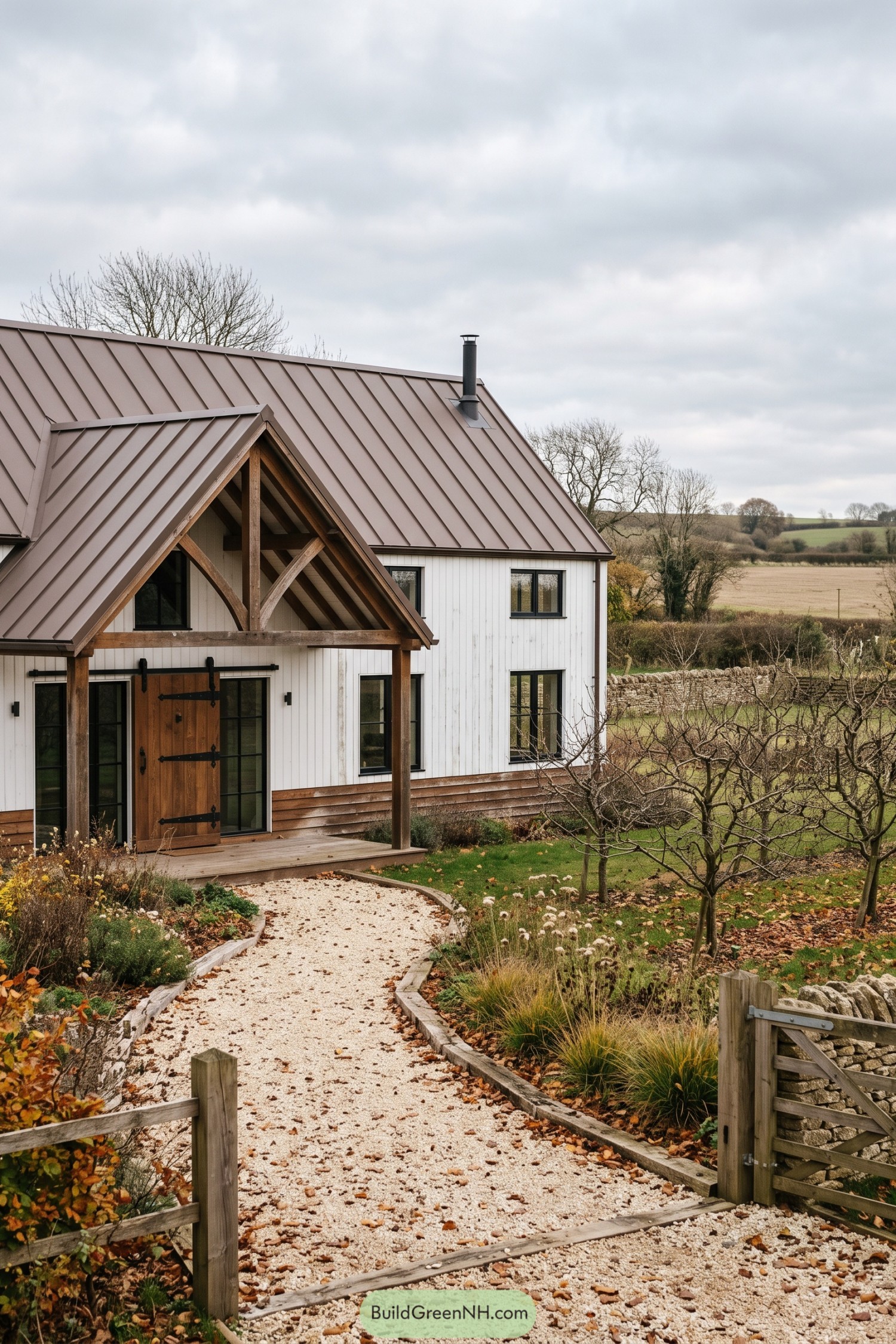 White barn house with timber porch and bronze metal roof