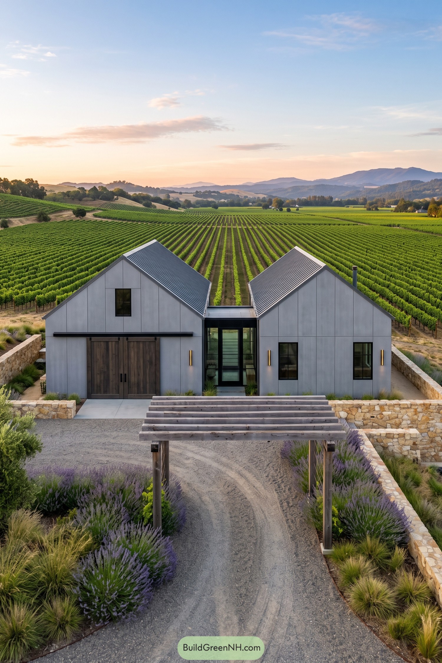 Gray twin gable barn home overlooking vineyard rows