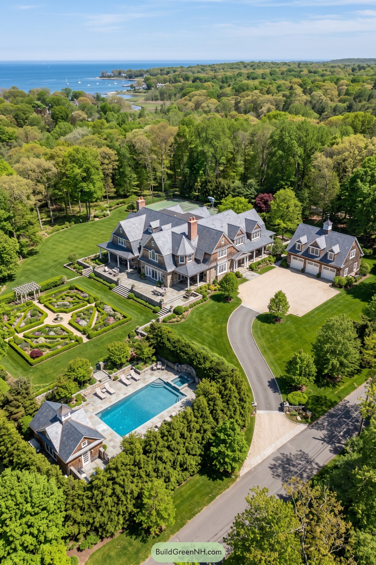 Aerial view of cedar-shingled coastal estate with pool and gardens