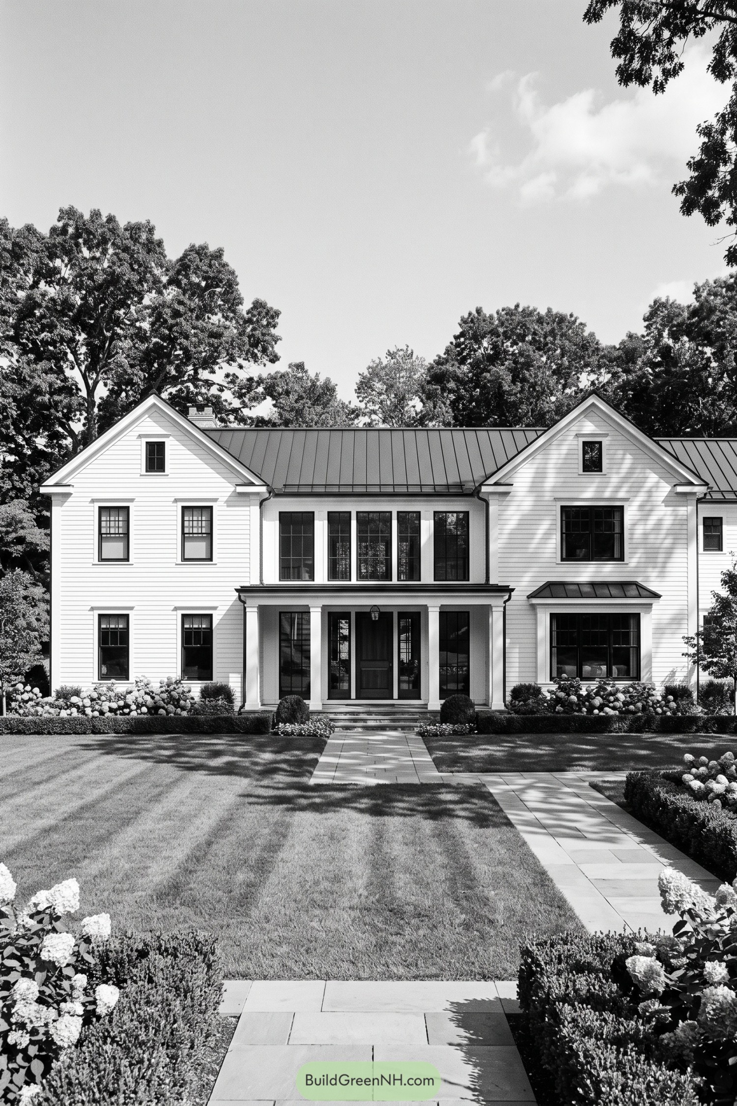 White clapboard home with twin gables and a standing seam roof