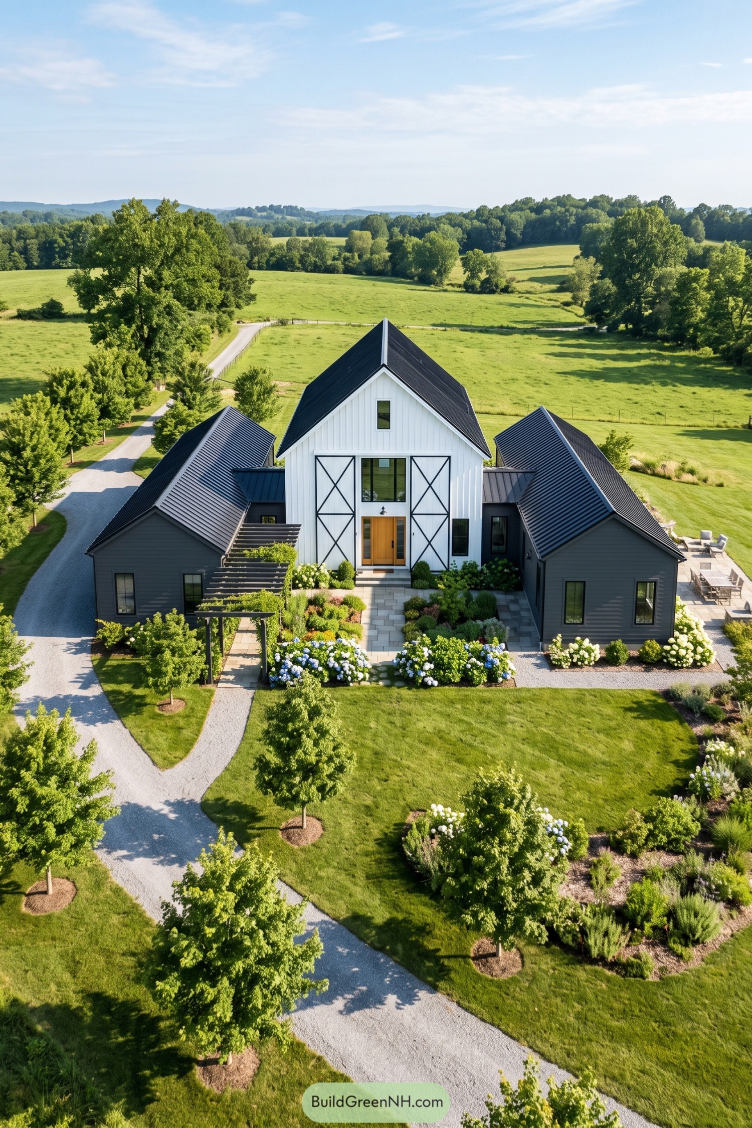 White barn house with charcoal side wings in green countryside