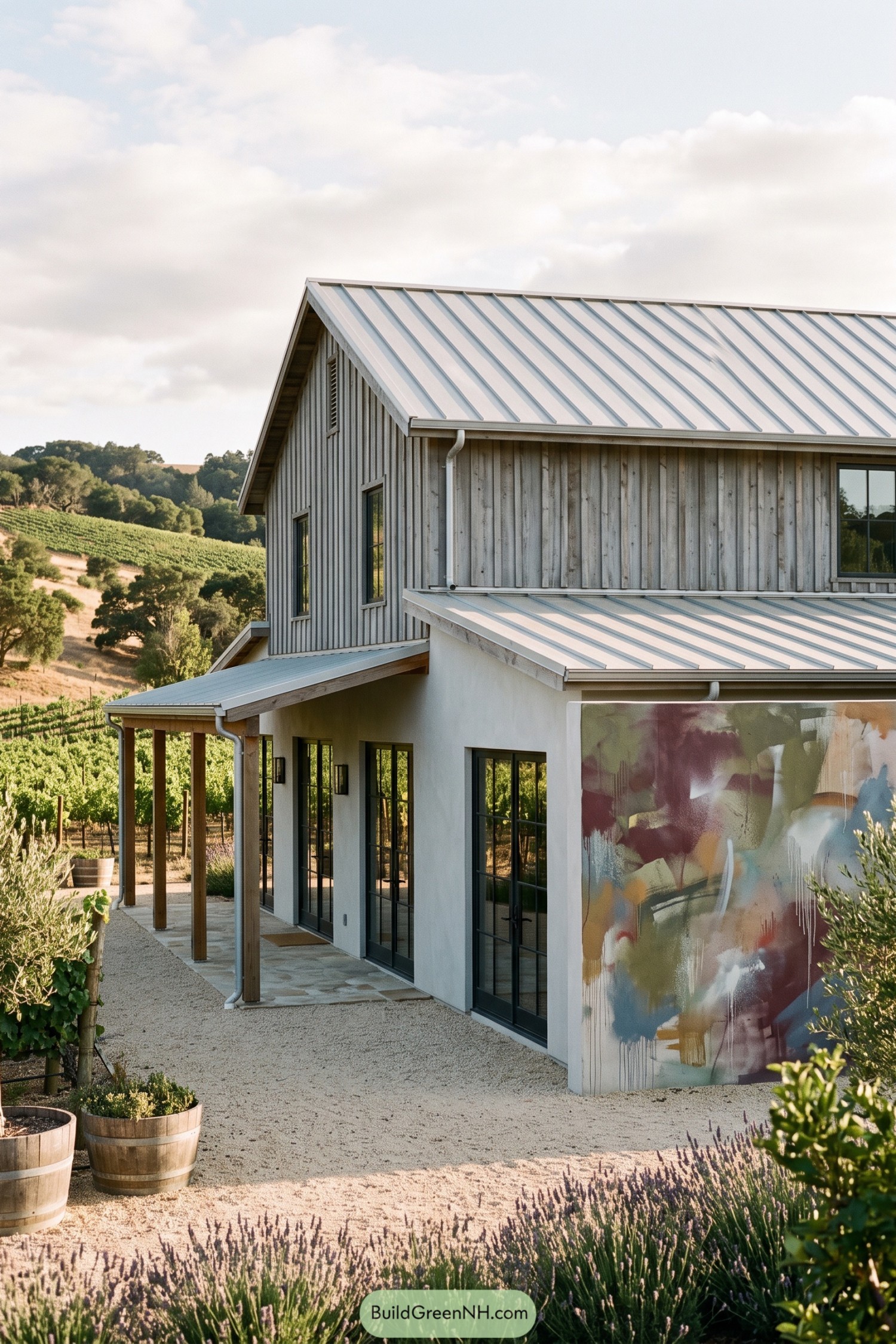 Modern barnhouse with abstract mural wall beside vineyard rows