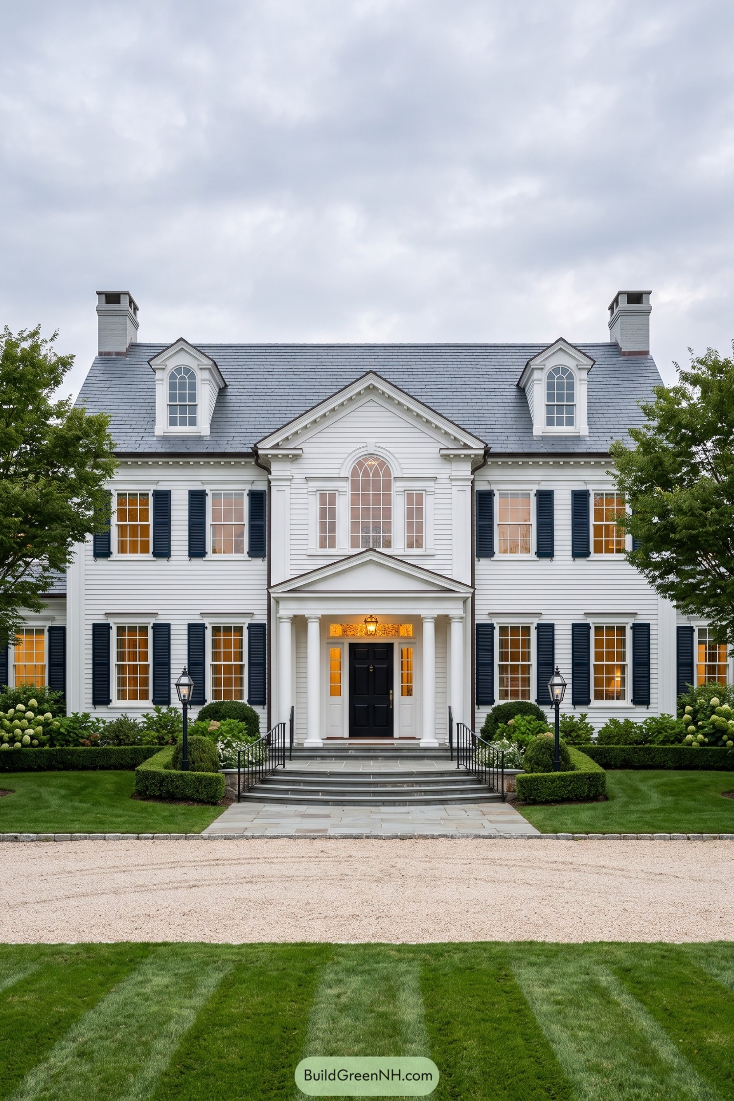 White Georgian Revival home with navy shutters and columned entry