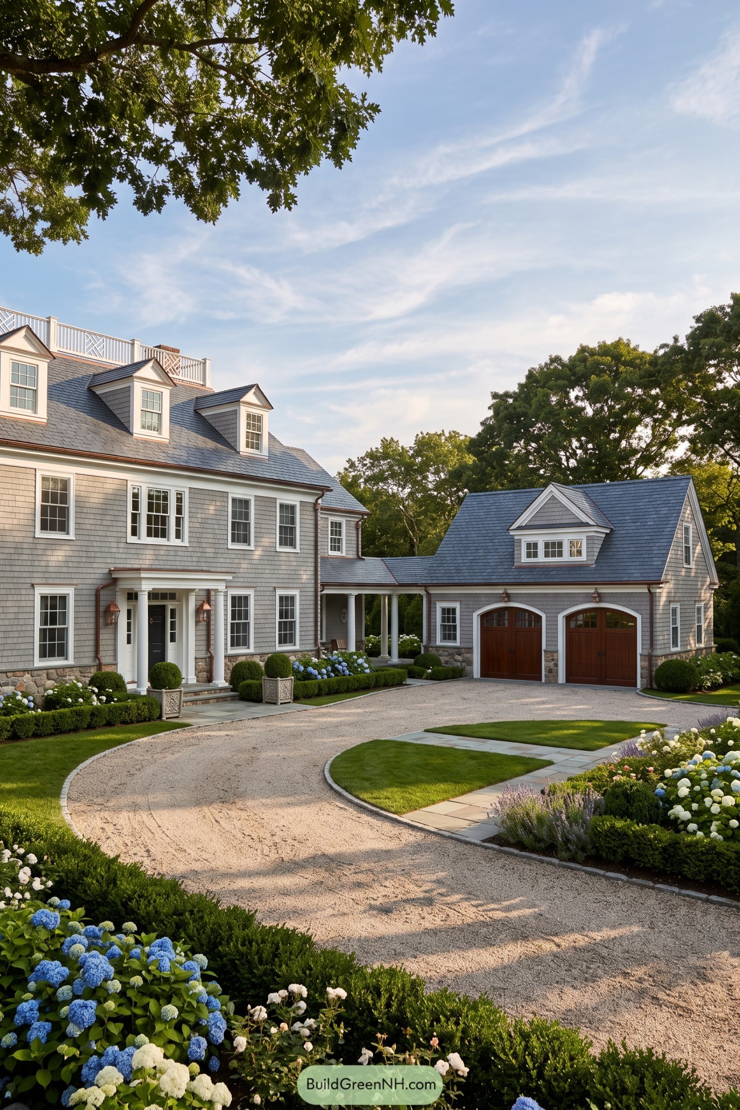 Gray shingle residence with slate roofs and an arched garage