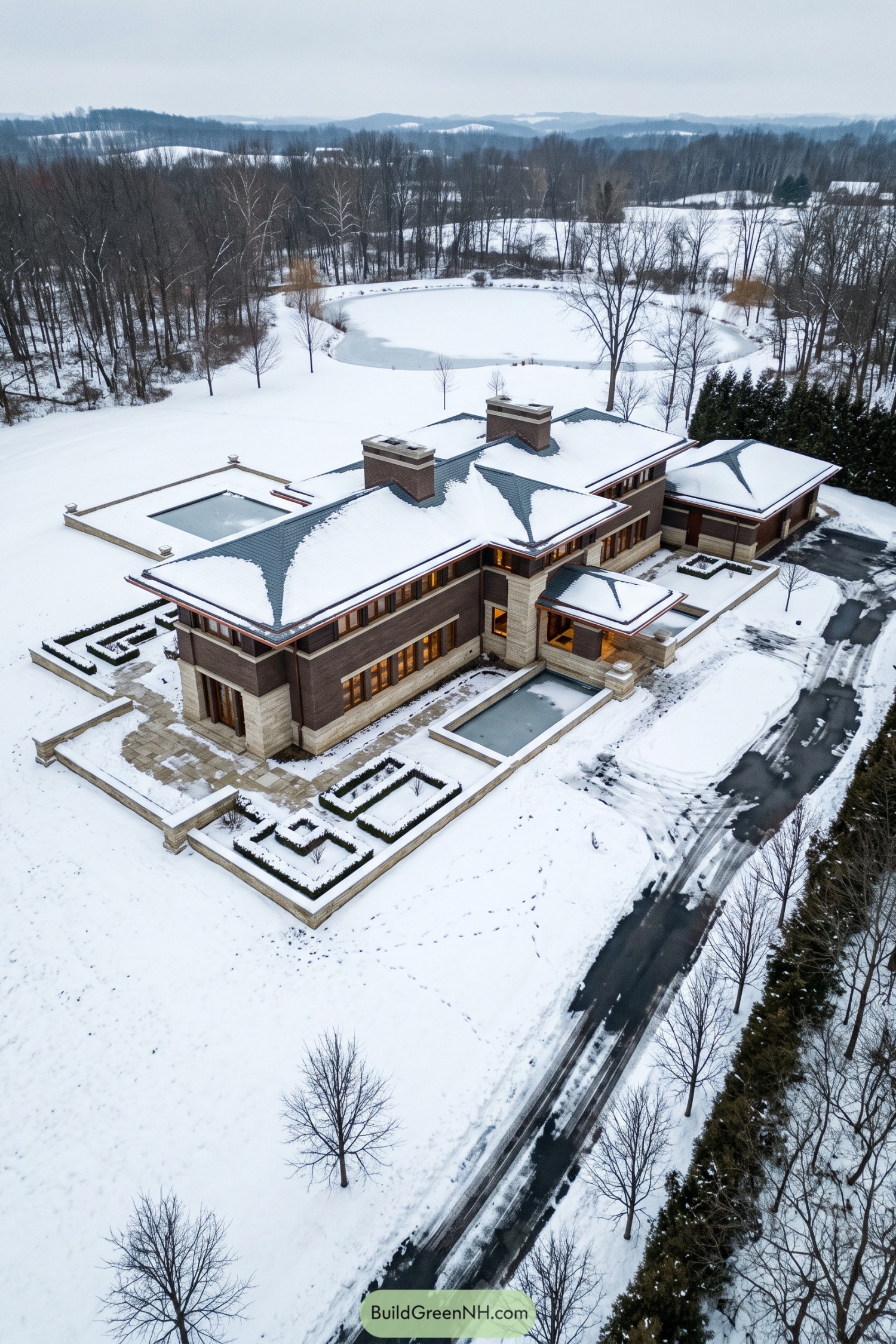 Snow-covered Prairie-style estate beside a frozen pond