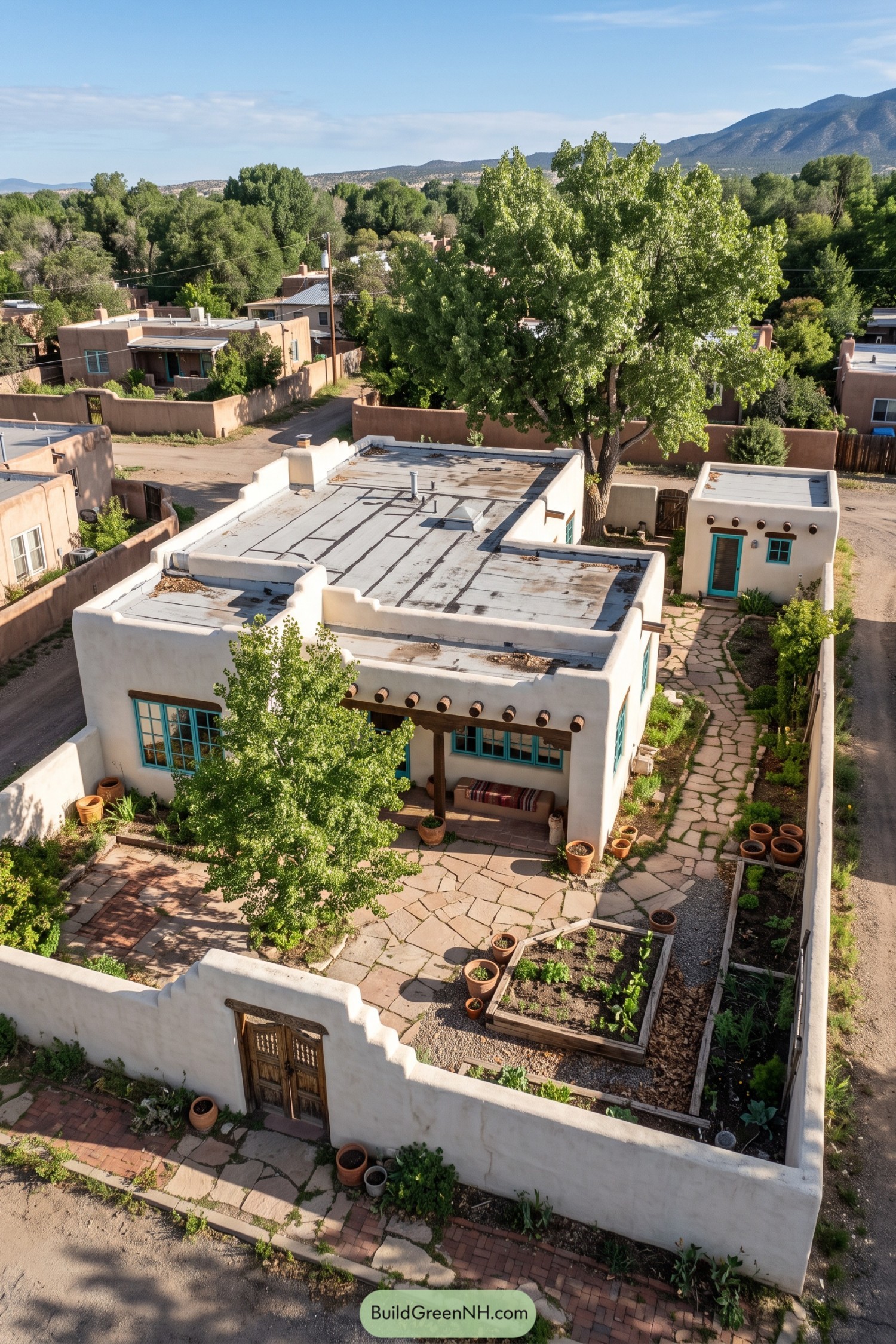 White pueblo home with turquoise windows and a walled garden