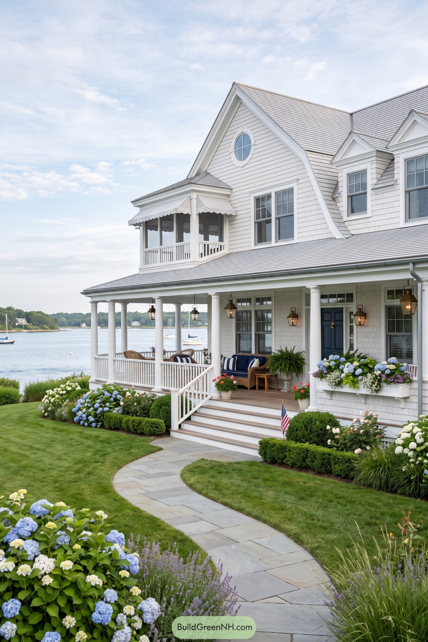 White shingle house with a columned porch overlooking a harbor