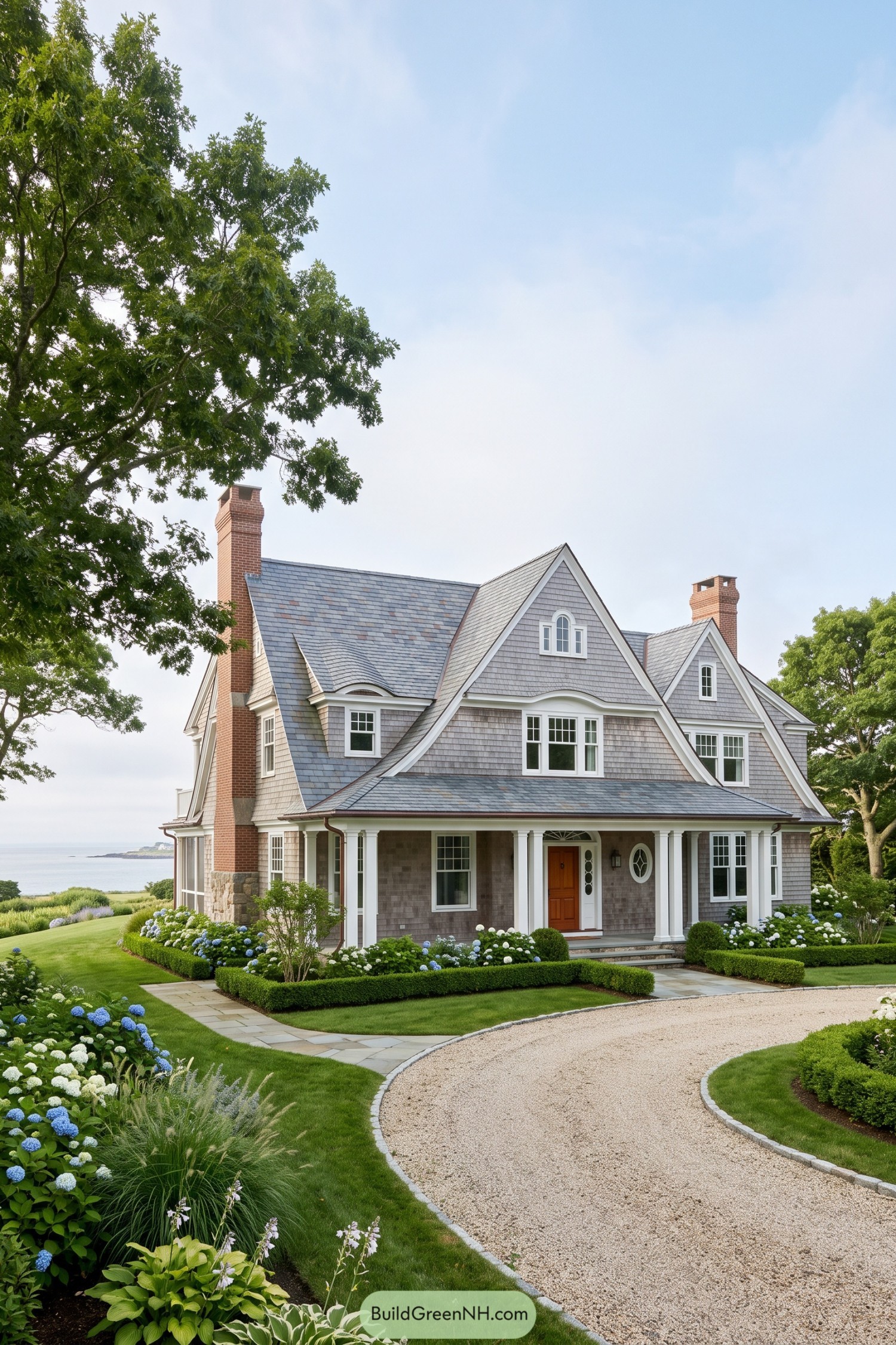 Gray shingle house with steep gables and a wraparound porch