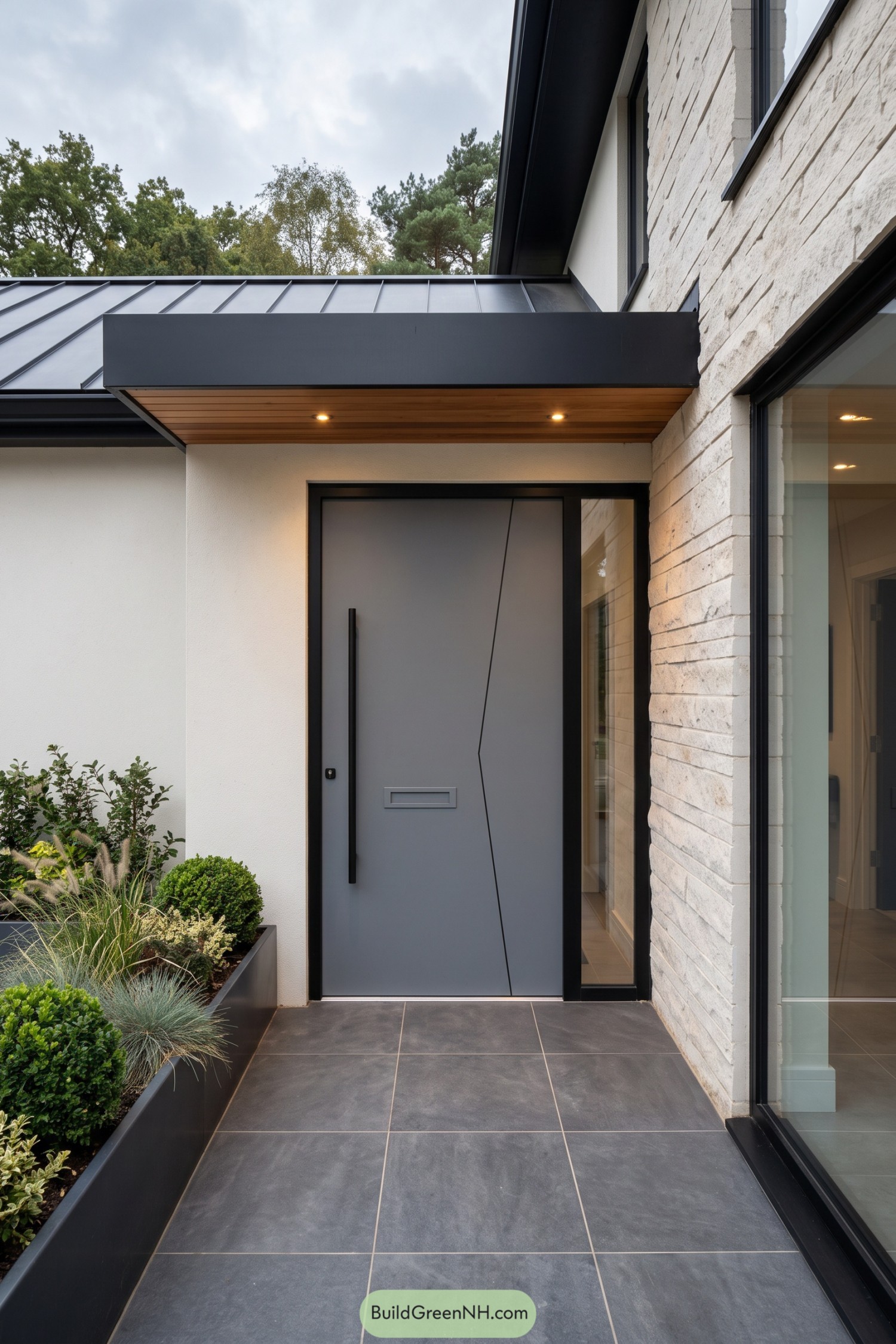Graphite front door beneath a wood-lined canopy