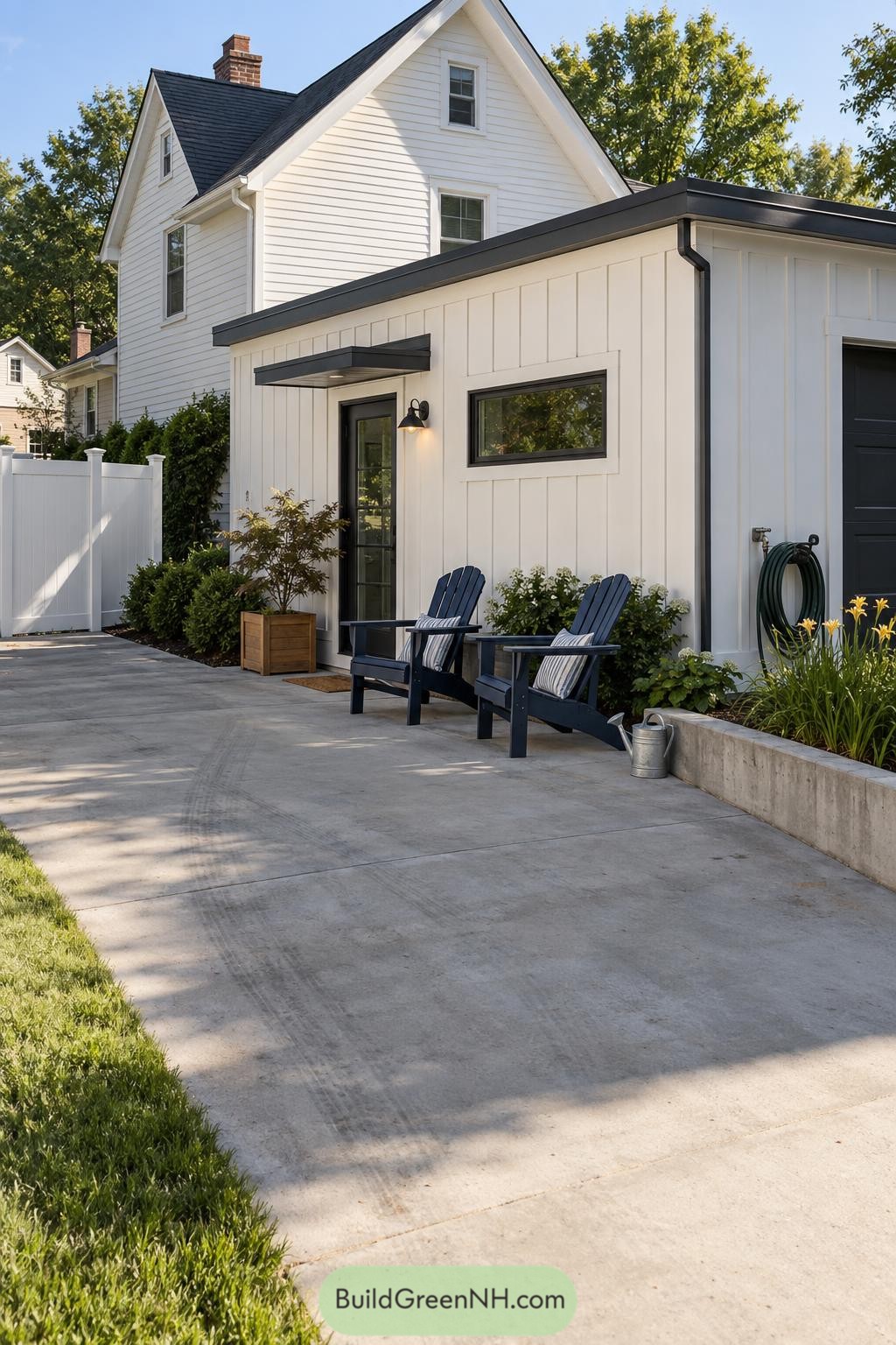 White flat roof addition with black trim and patio seating