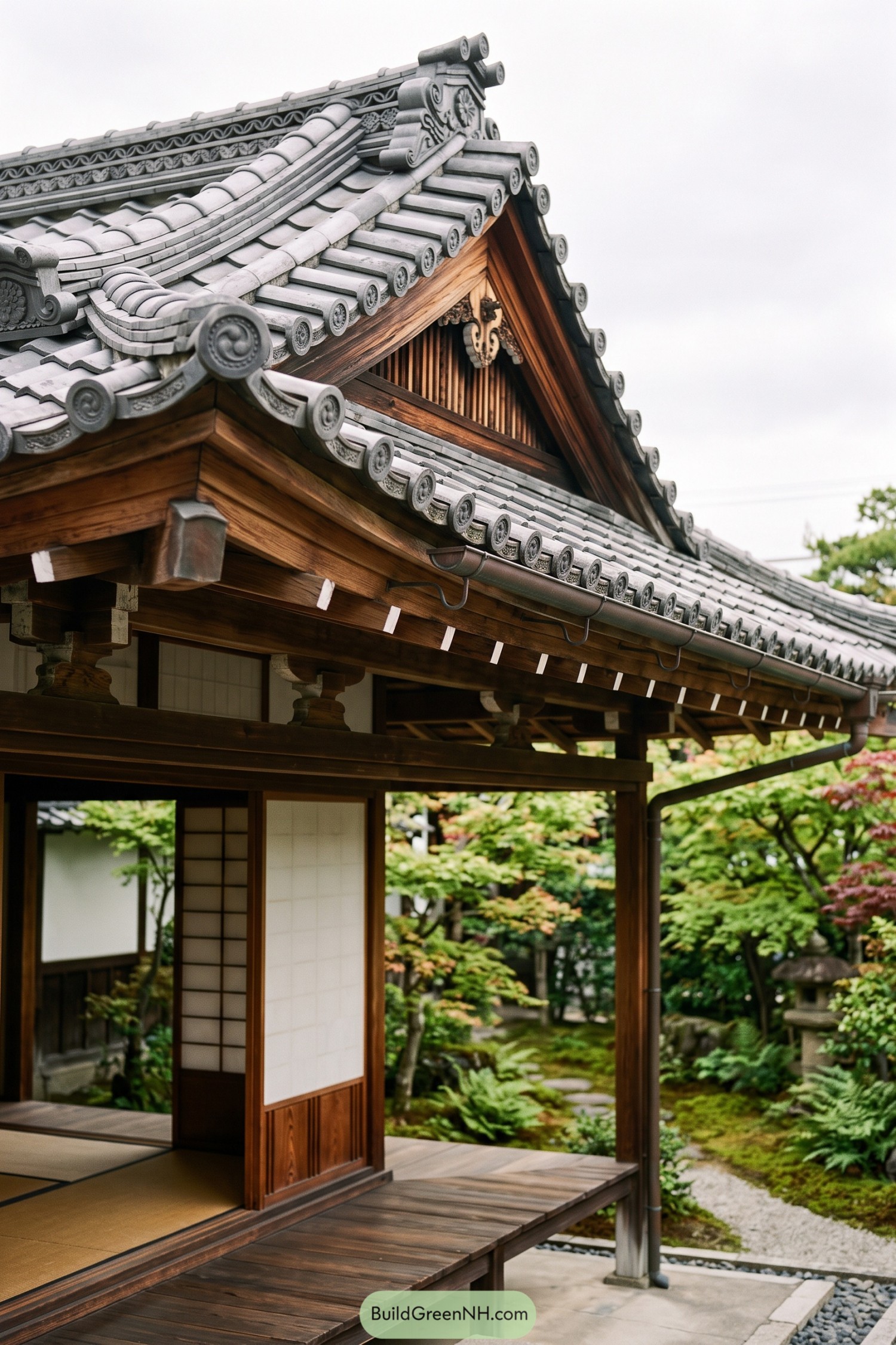 Grey kawara tiles frame a carved gable above a timber veranda