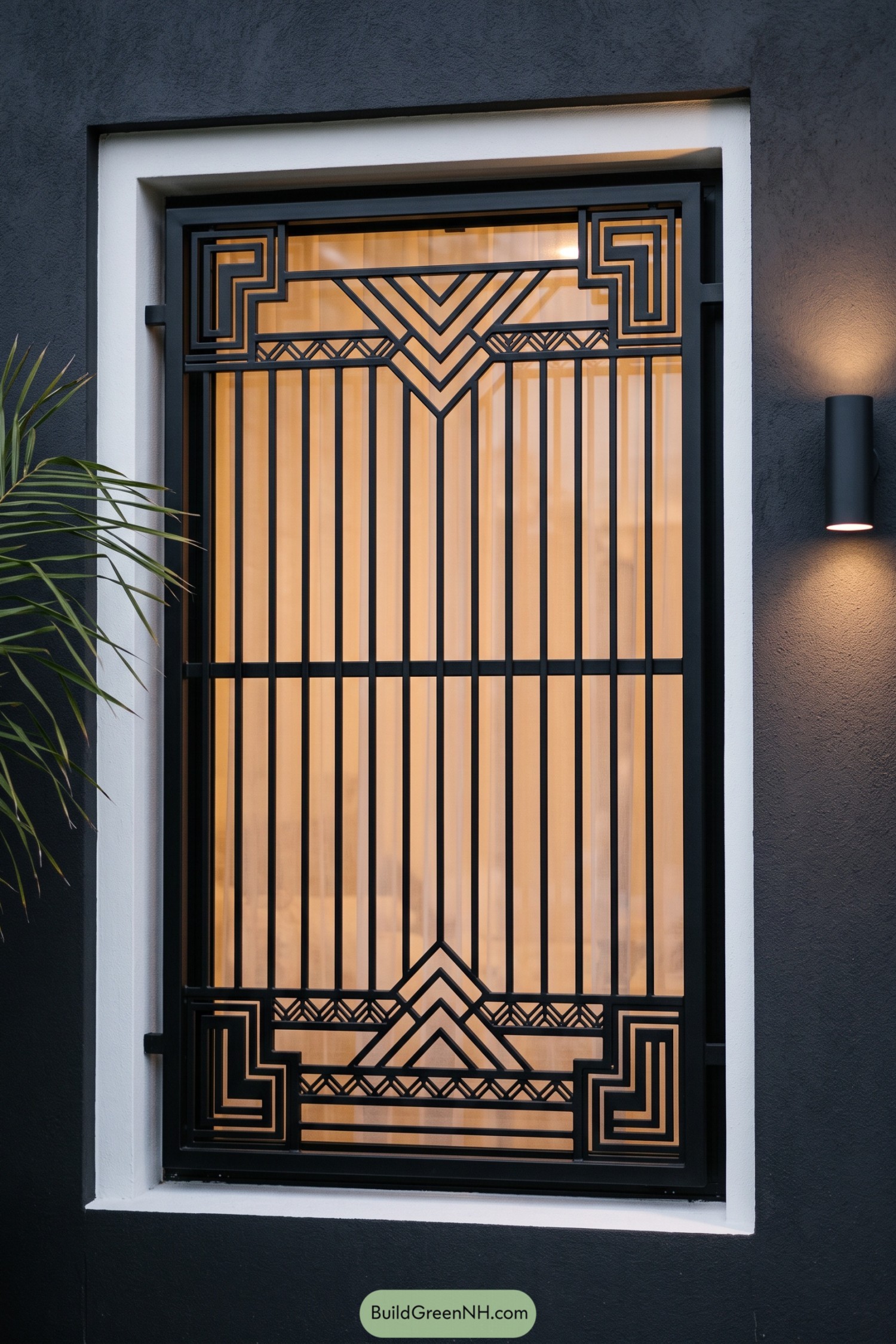 Black metal window grill with chevrons and stepped corner motifs