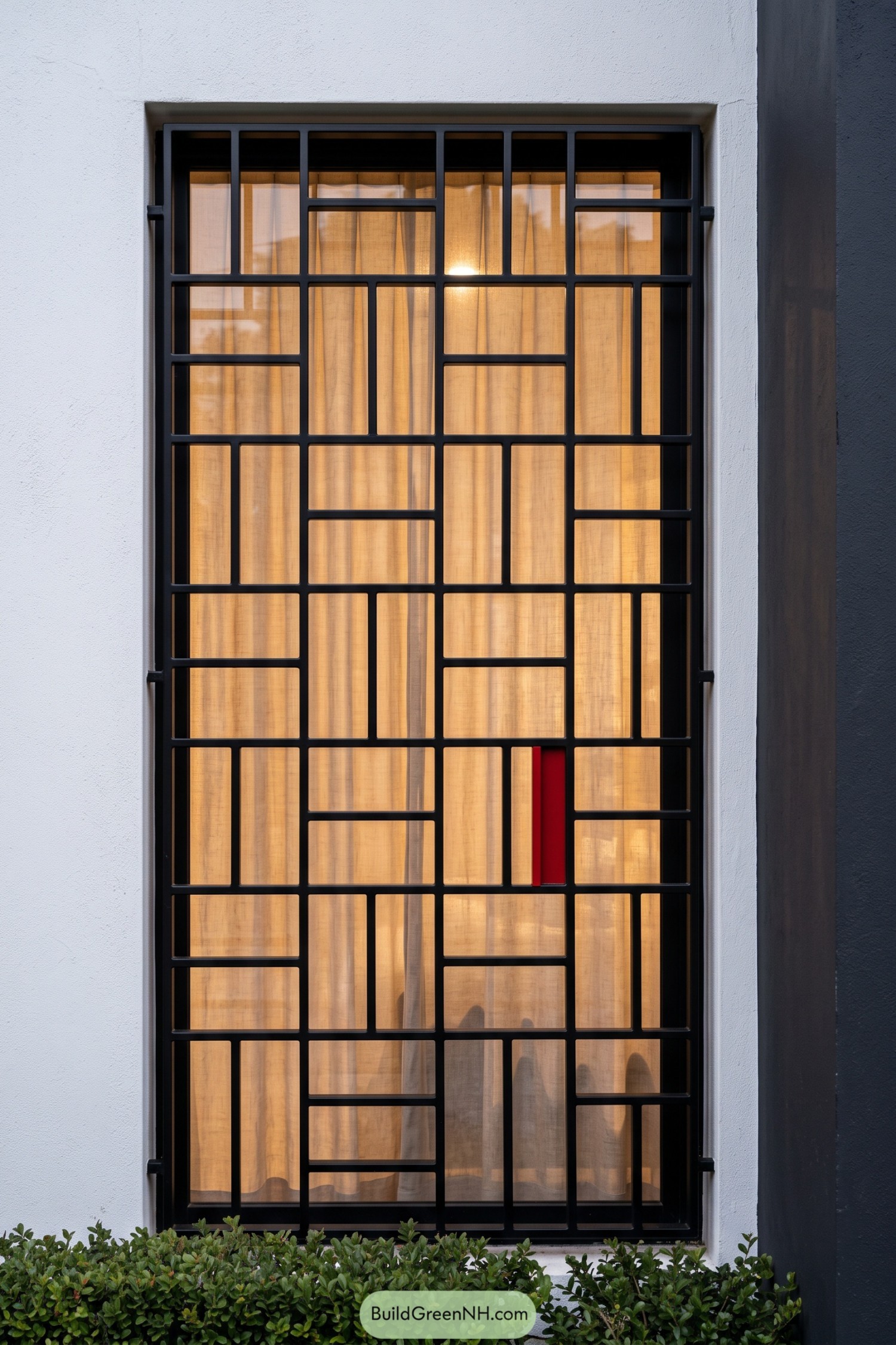 Black geometric window grill with a red accent panel