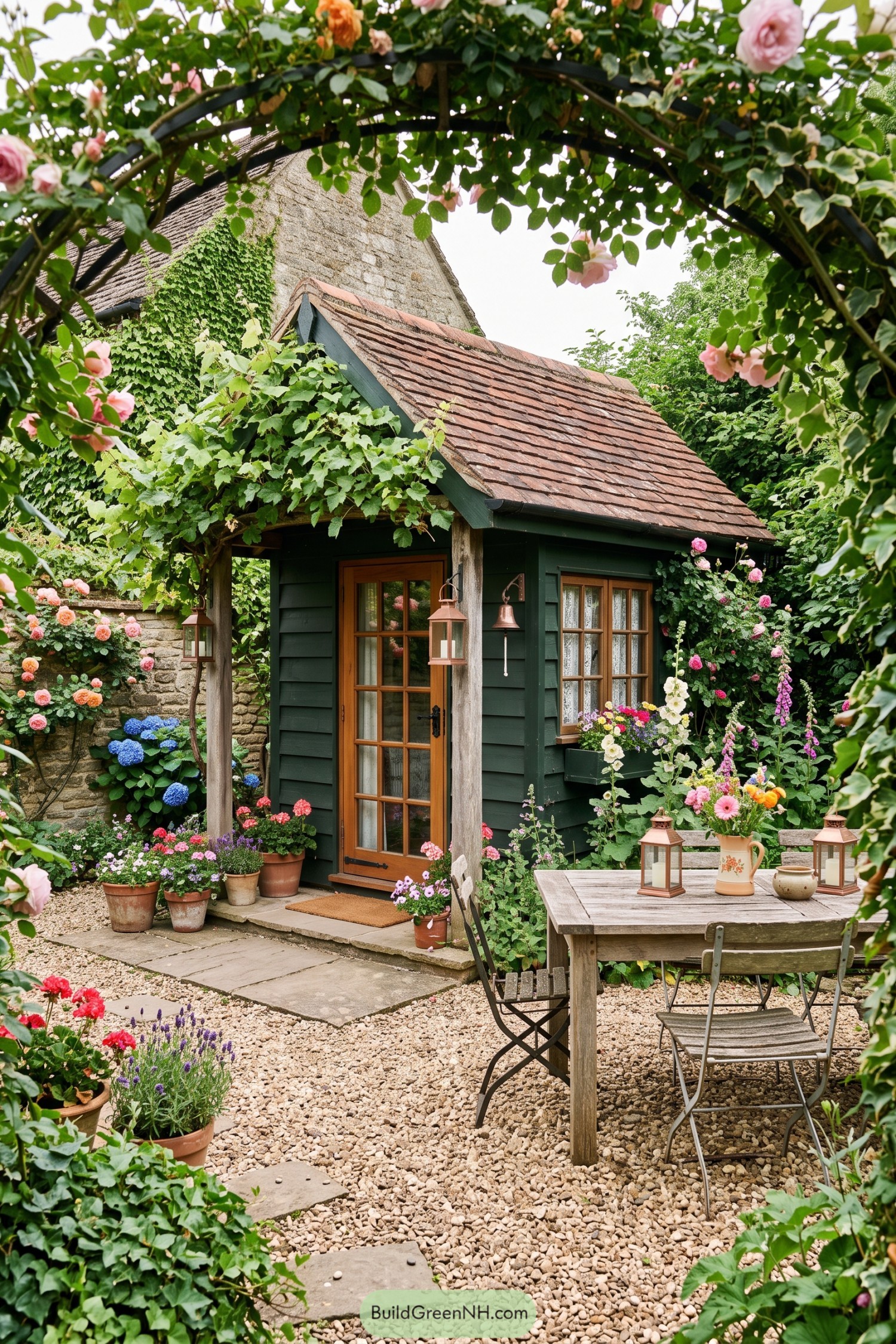 Dark green shed with timber porch beneath roses