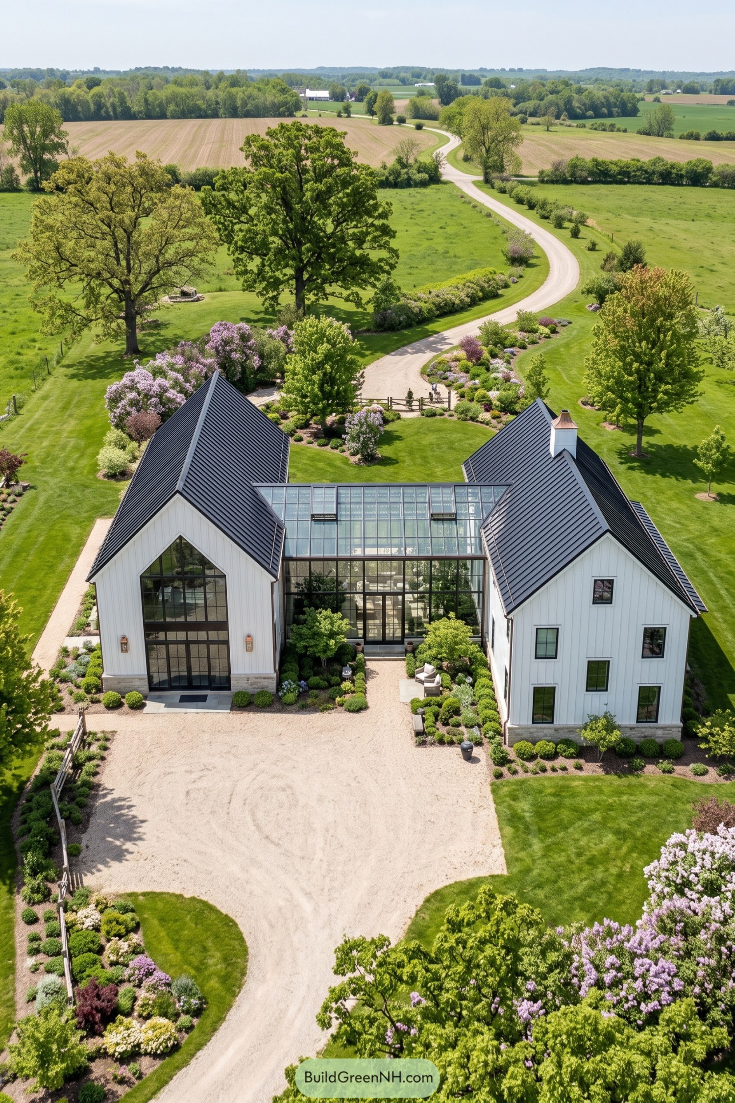 Aerial view of white gabled barns linked by a glazed winter garden